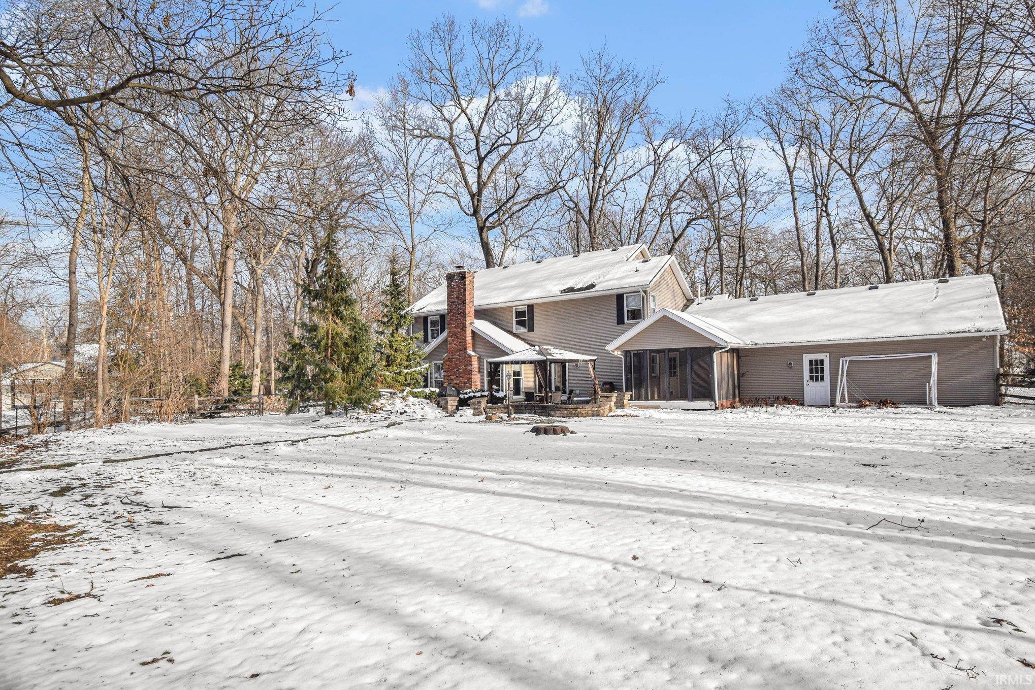 View of front of house featuring a chimney and a deck