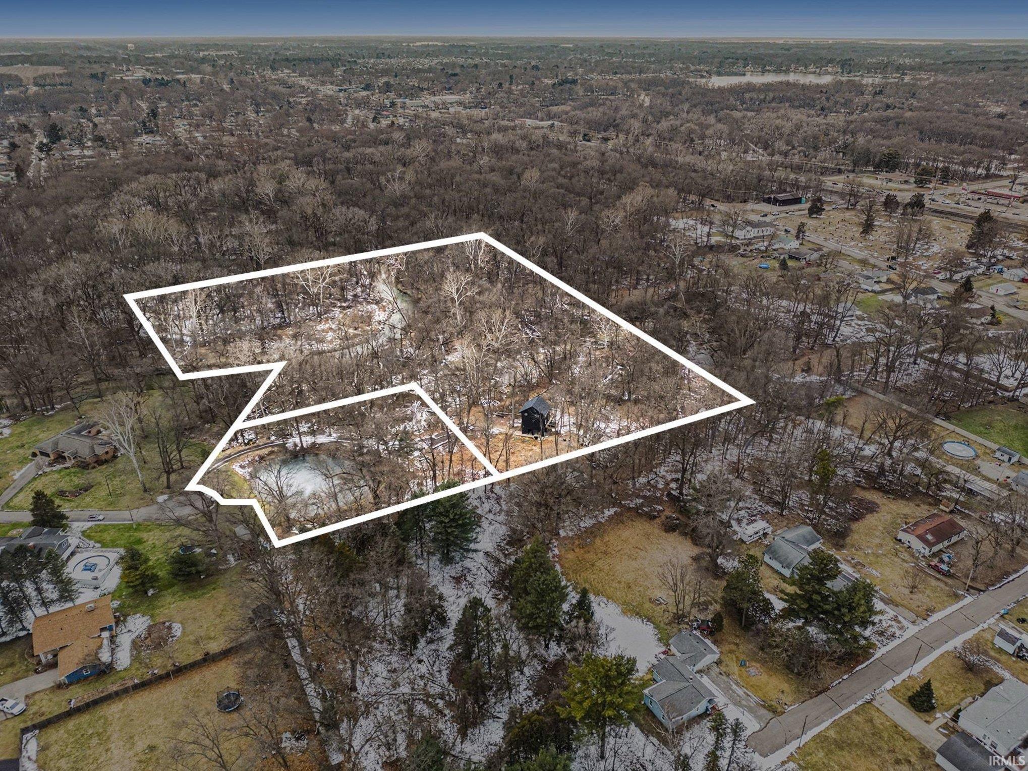 Aerial overview of property's location featuring property parcel outlined and a forest