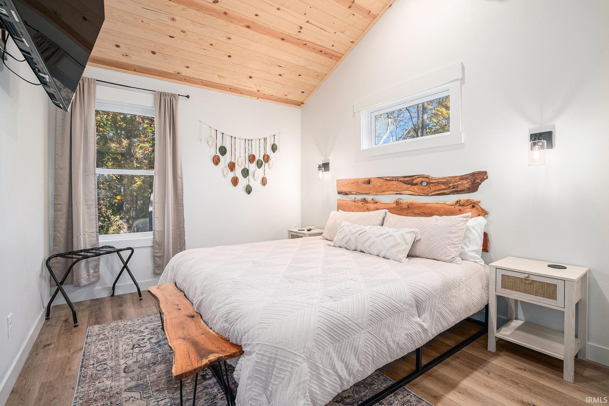 Bedroom featuring light wood-style floors and a vaulted wooden ceiling