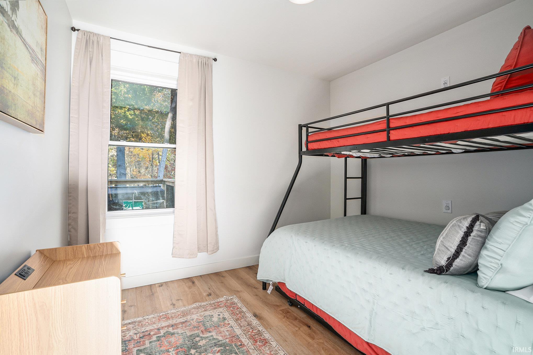 Bedroom with light wood finished floors and baseboards