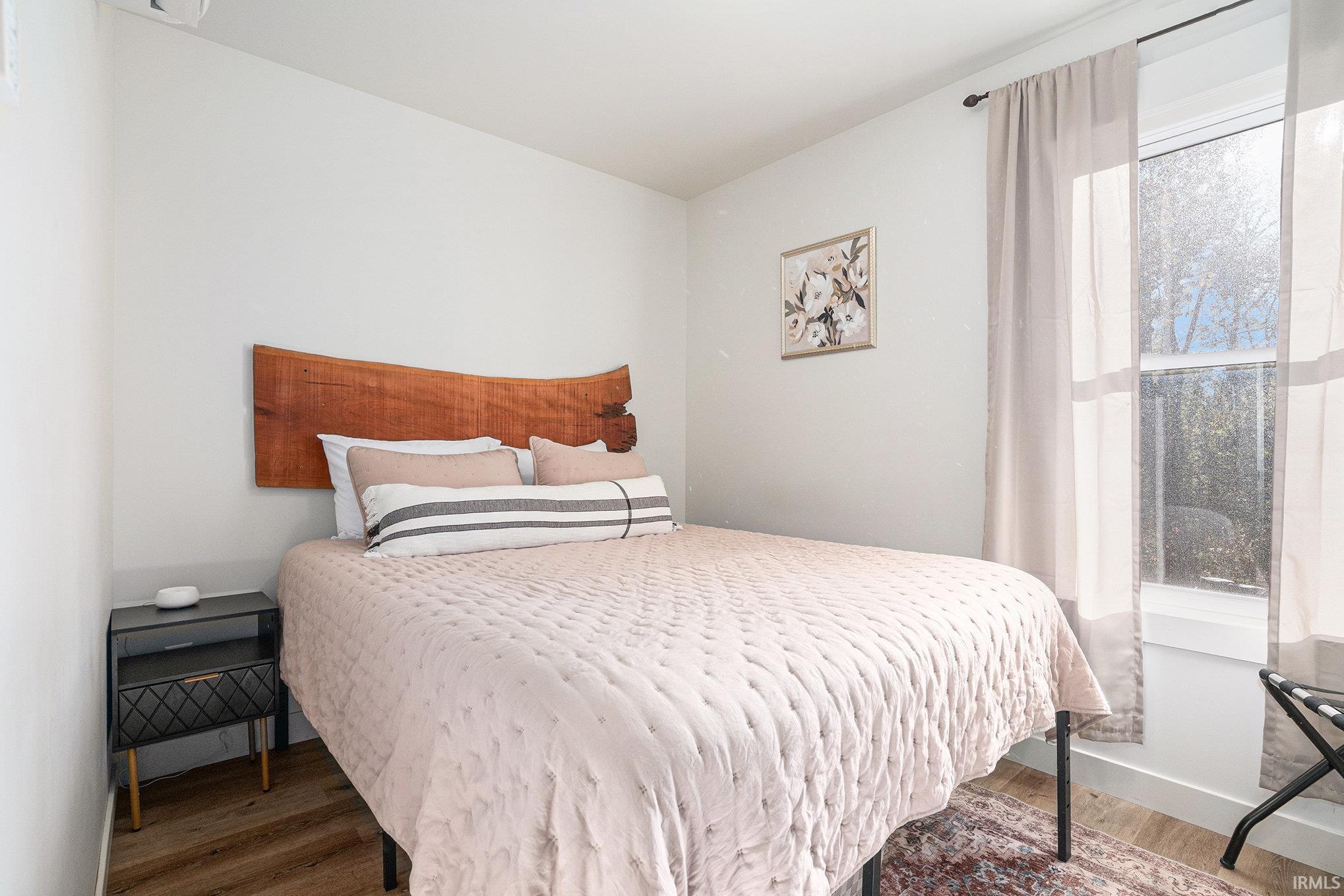 Bedroom with wood finished floors and baseboards