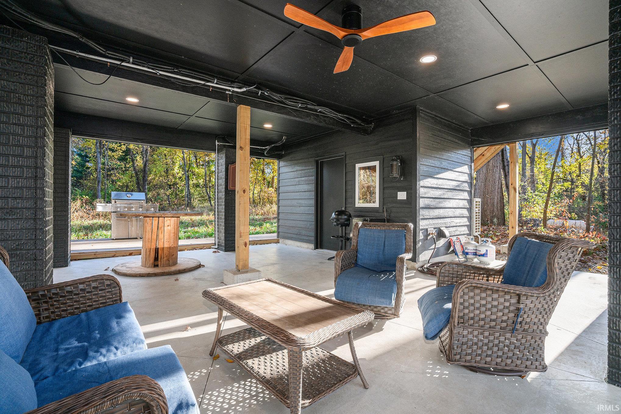 View of patio with outdoor lounge area, ceiling fan, and area for grilling