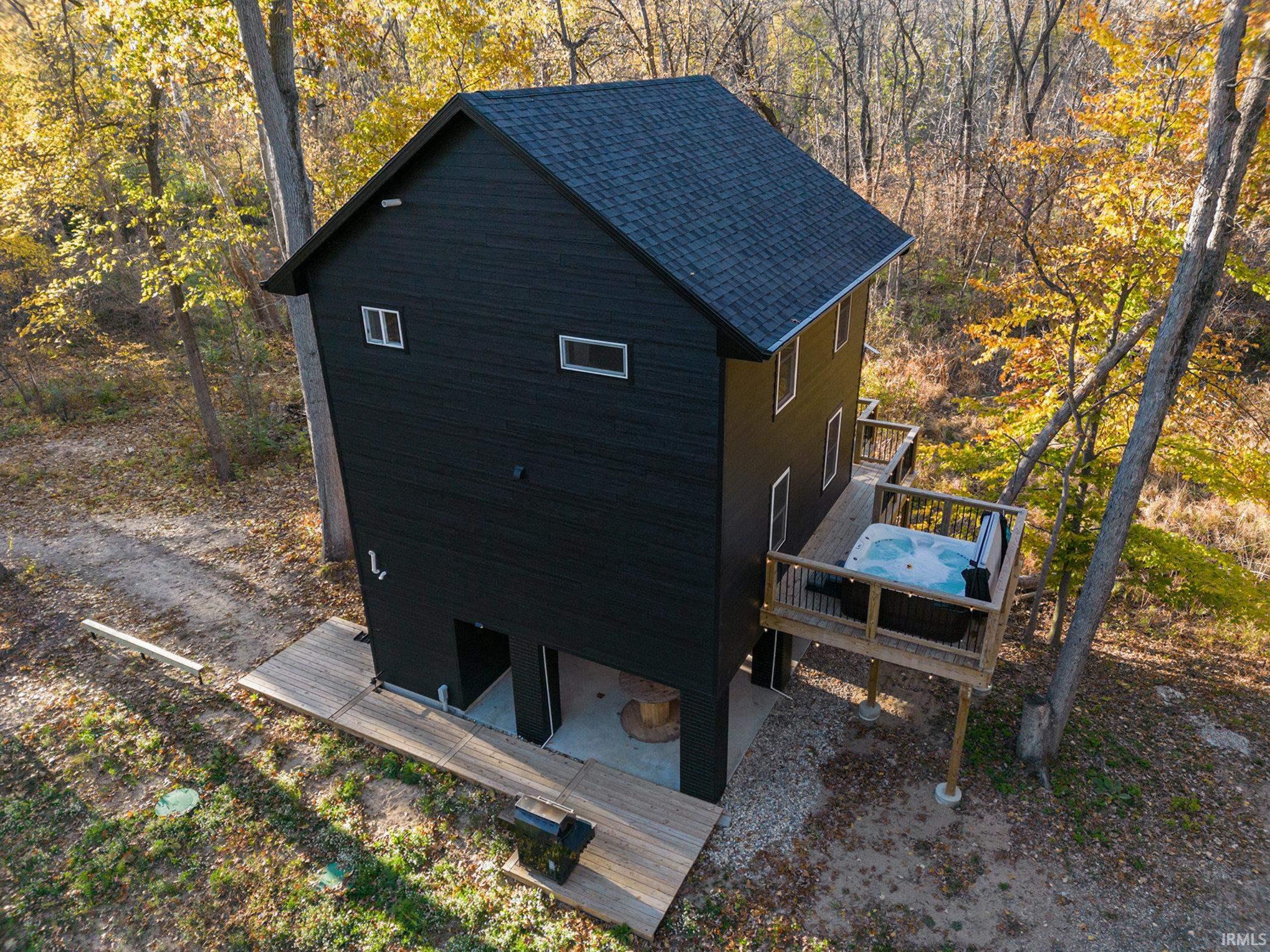 View of property exterior featuring a deck and roof with shingles