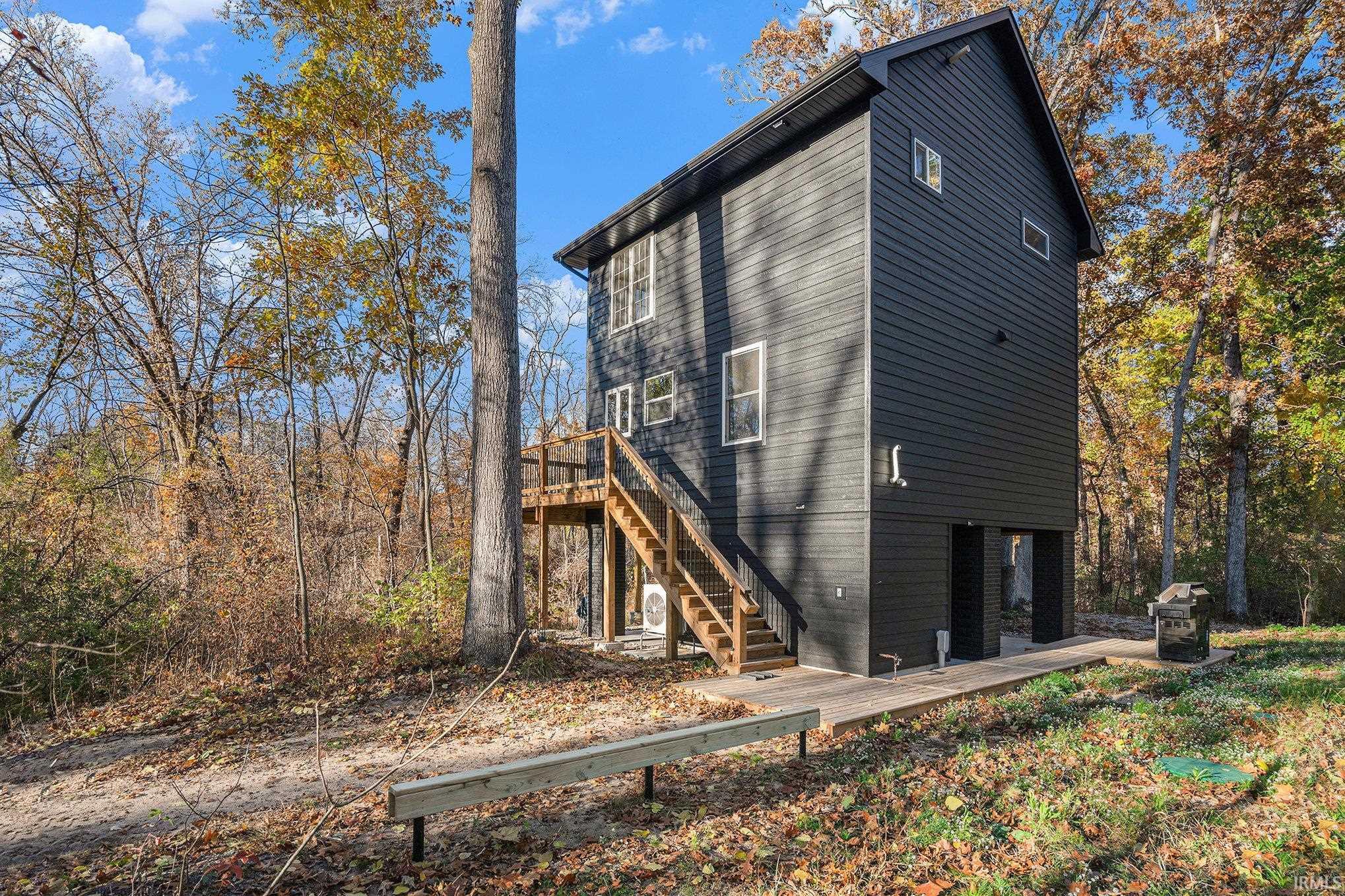 View of side of property with a wooden deck and stairway