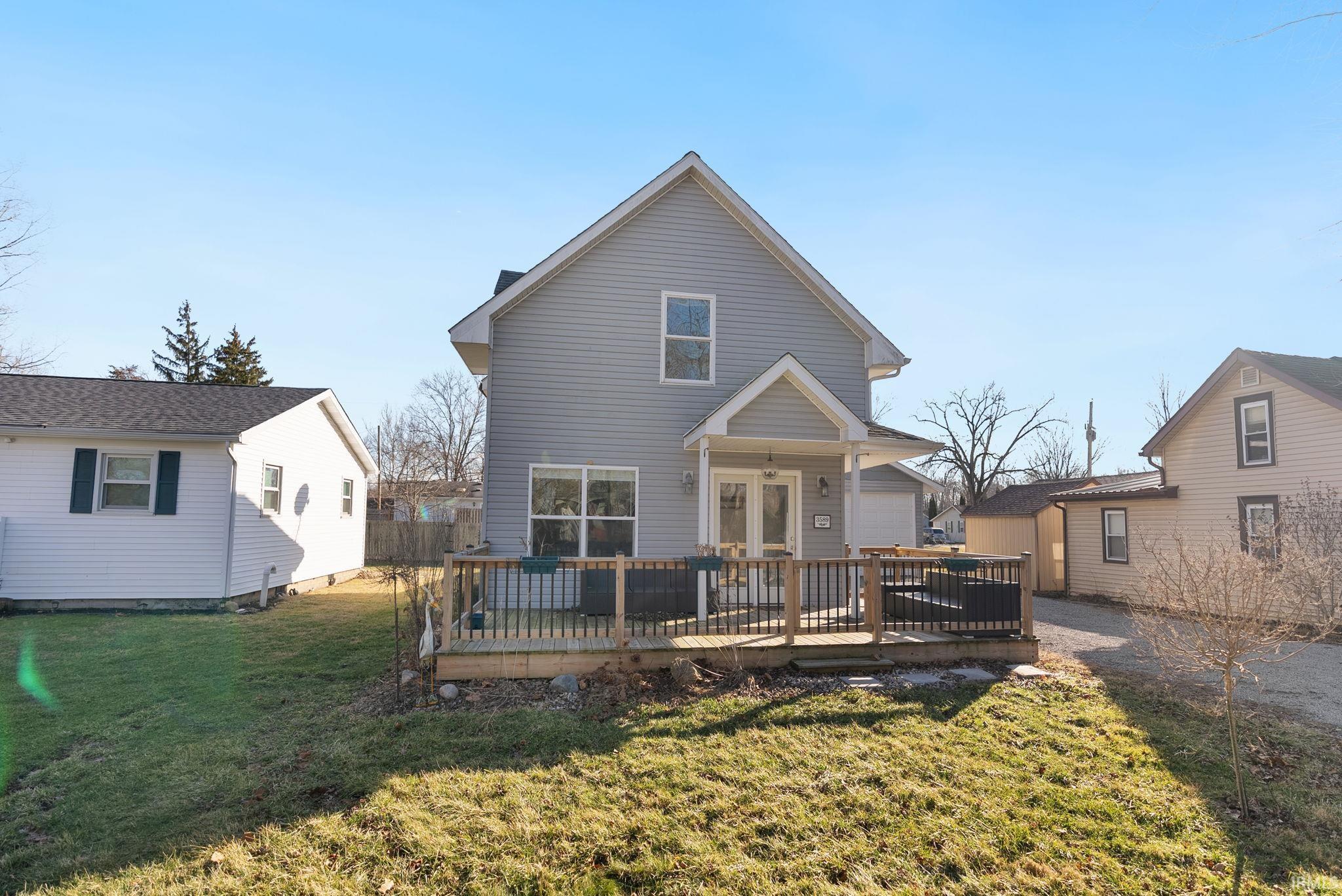 Rear view of property with a wooden deck and a yard