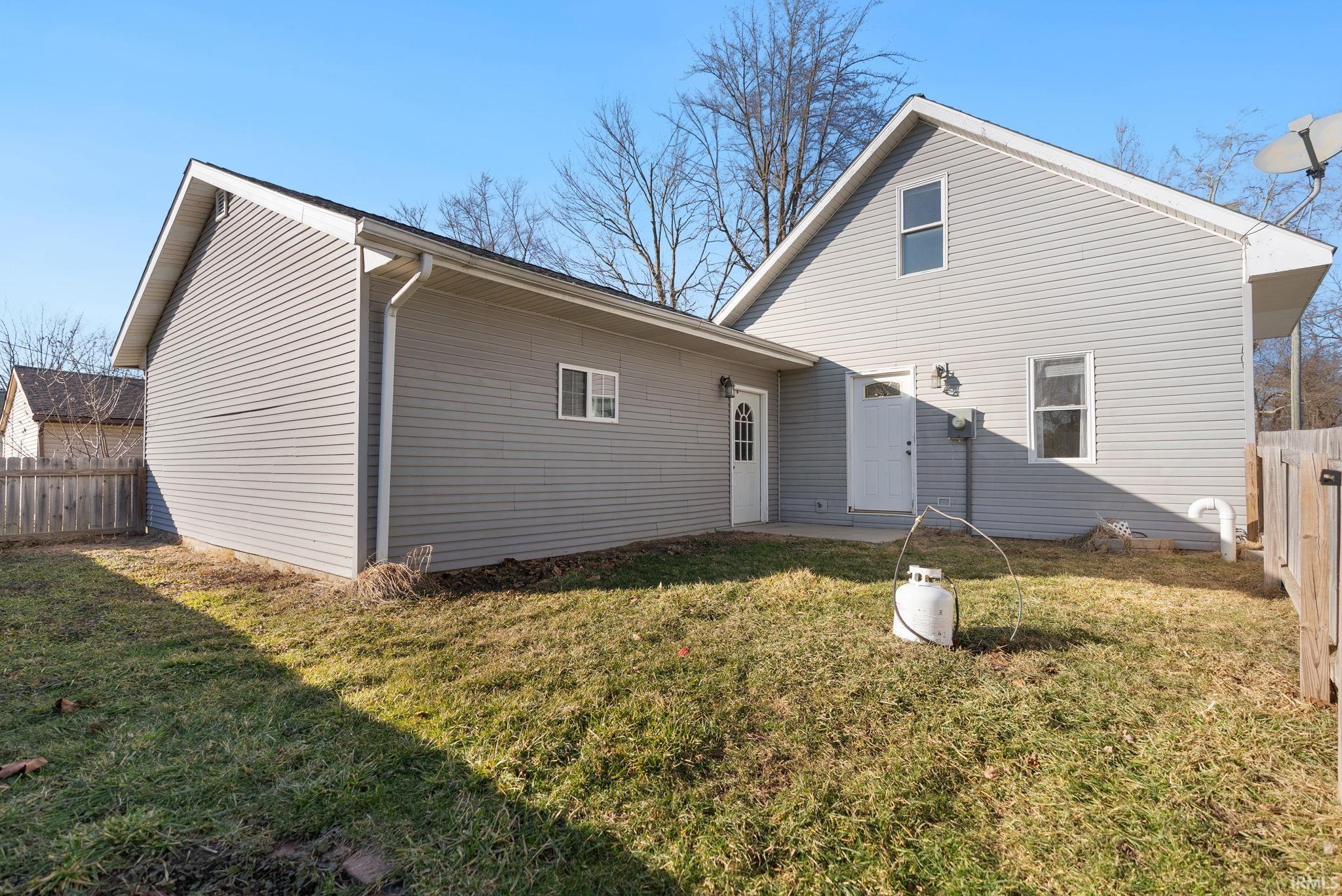 Rear view of house featuring a fenced backyard