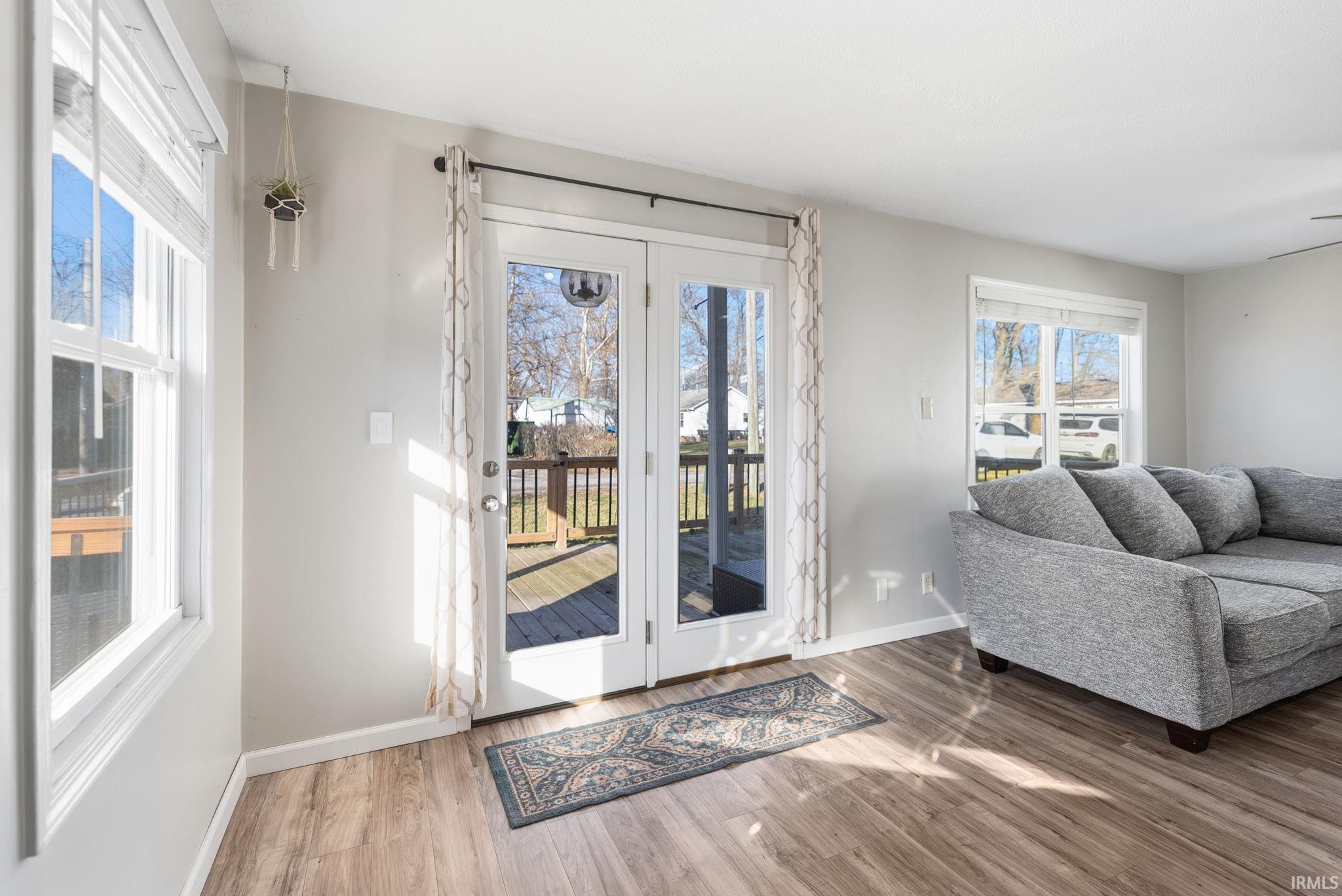 Doorway to outside featuring baseboards and wood finished floors