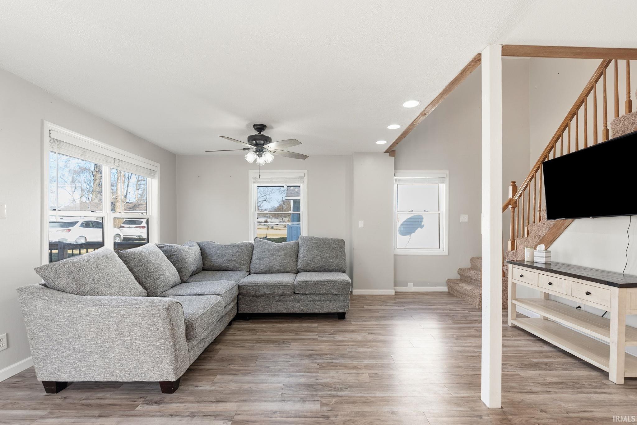 Living room featuring recessed lighting, light wood-type flooring, and a ceiling fan