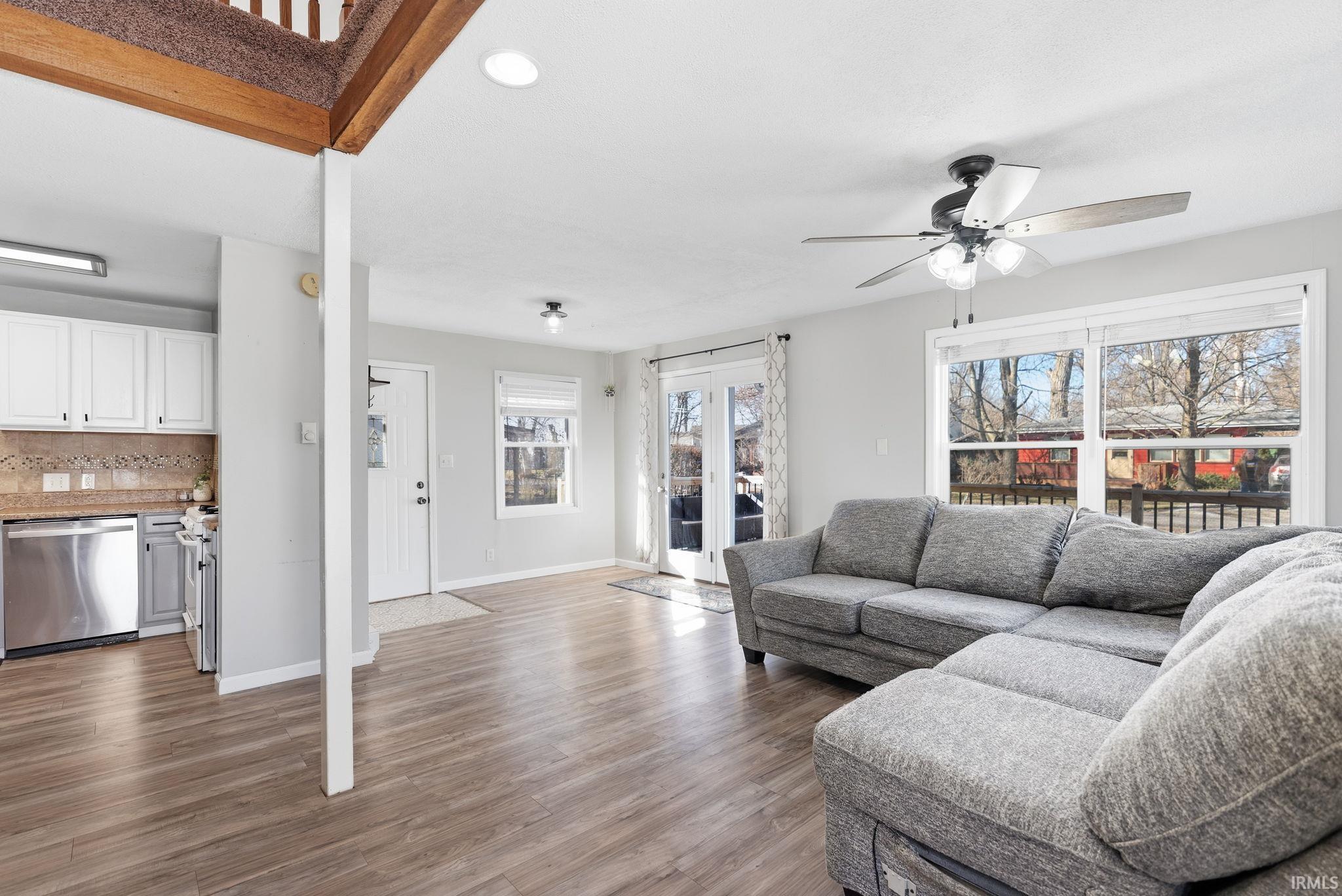 Living area with light wood finished floors, ceiling fan, and recessed lighting