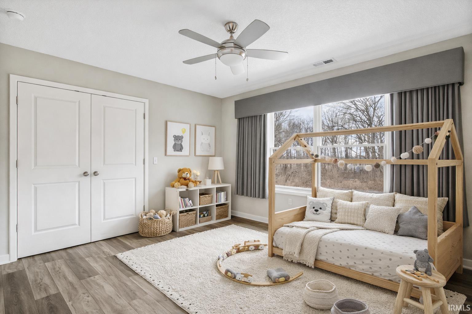 Bedroom featuring light wood-style floors, a closet, and ceiling fan