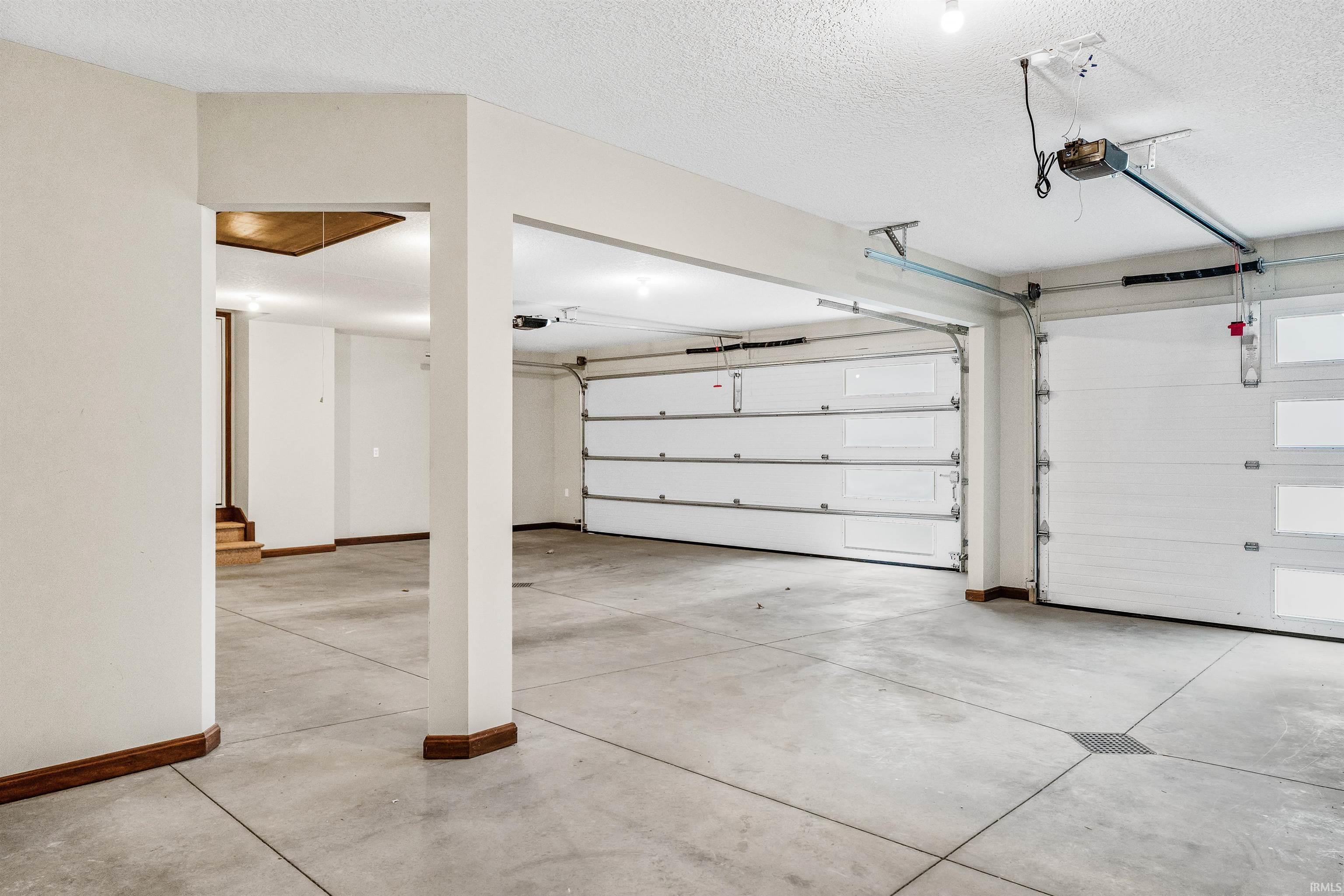 Garage featuring baseboards and a garage door opener