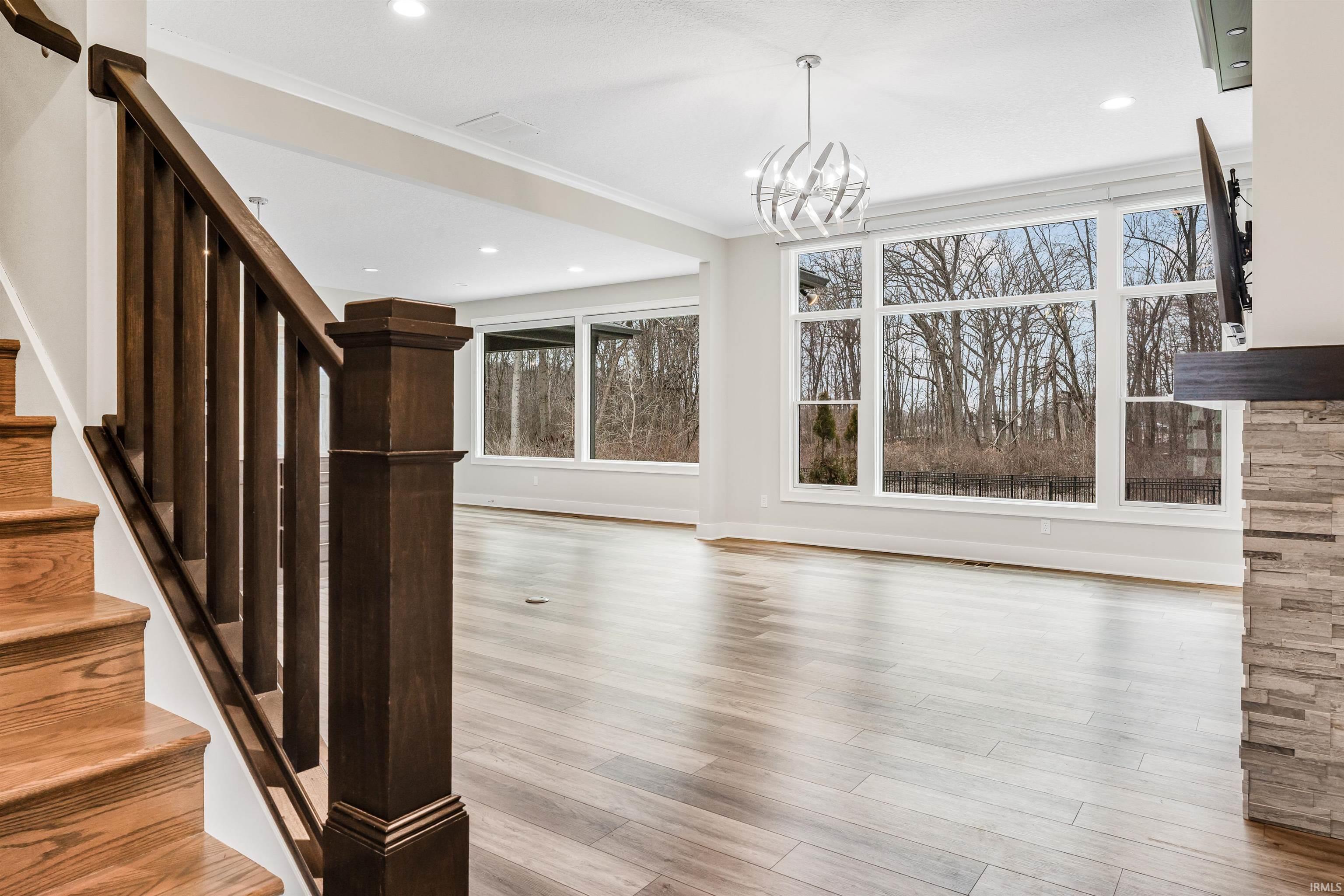 Unfurnished dining area with crown molding, light wood-style floors, and hanging lights