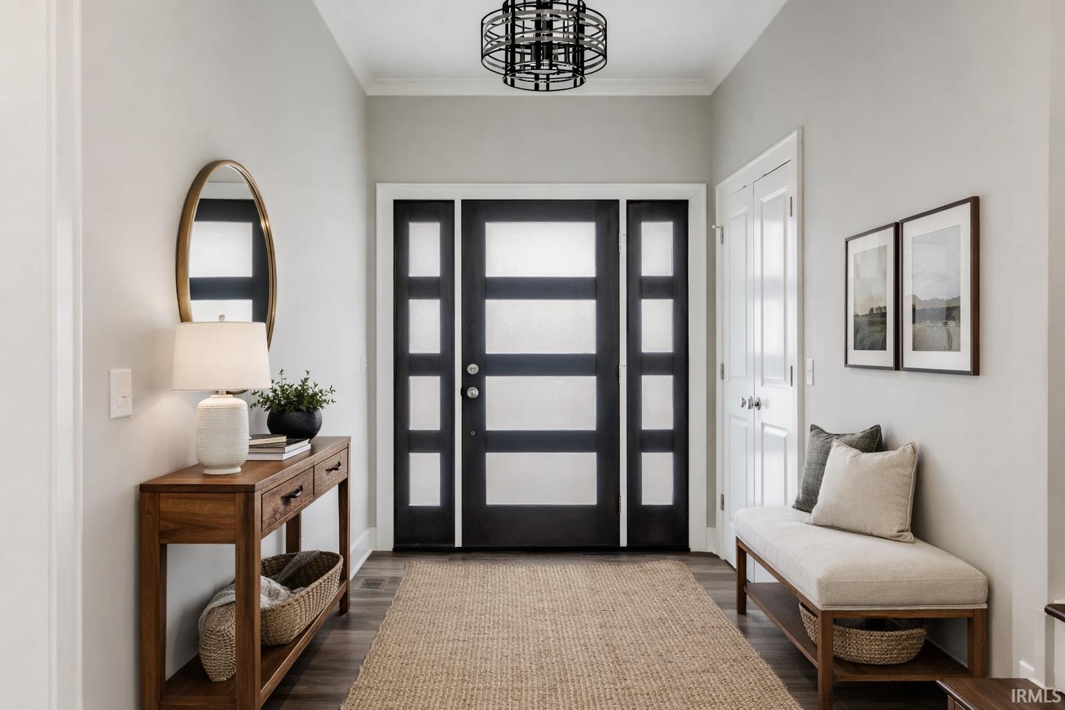 Entrance foyer featuring dark wood finished floors and crown molding