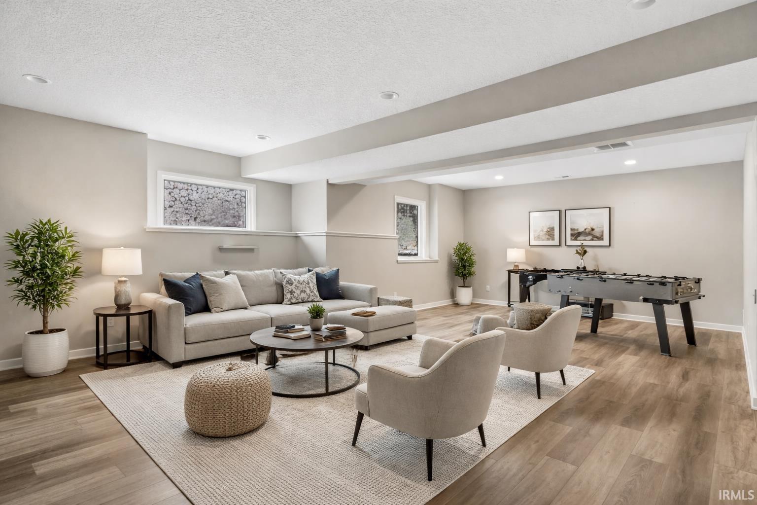 Living room with light wood finished floors, recessed lighting, and a textured ceiling