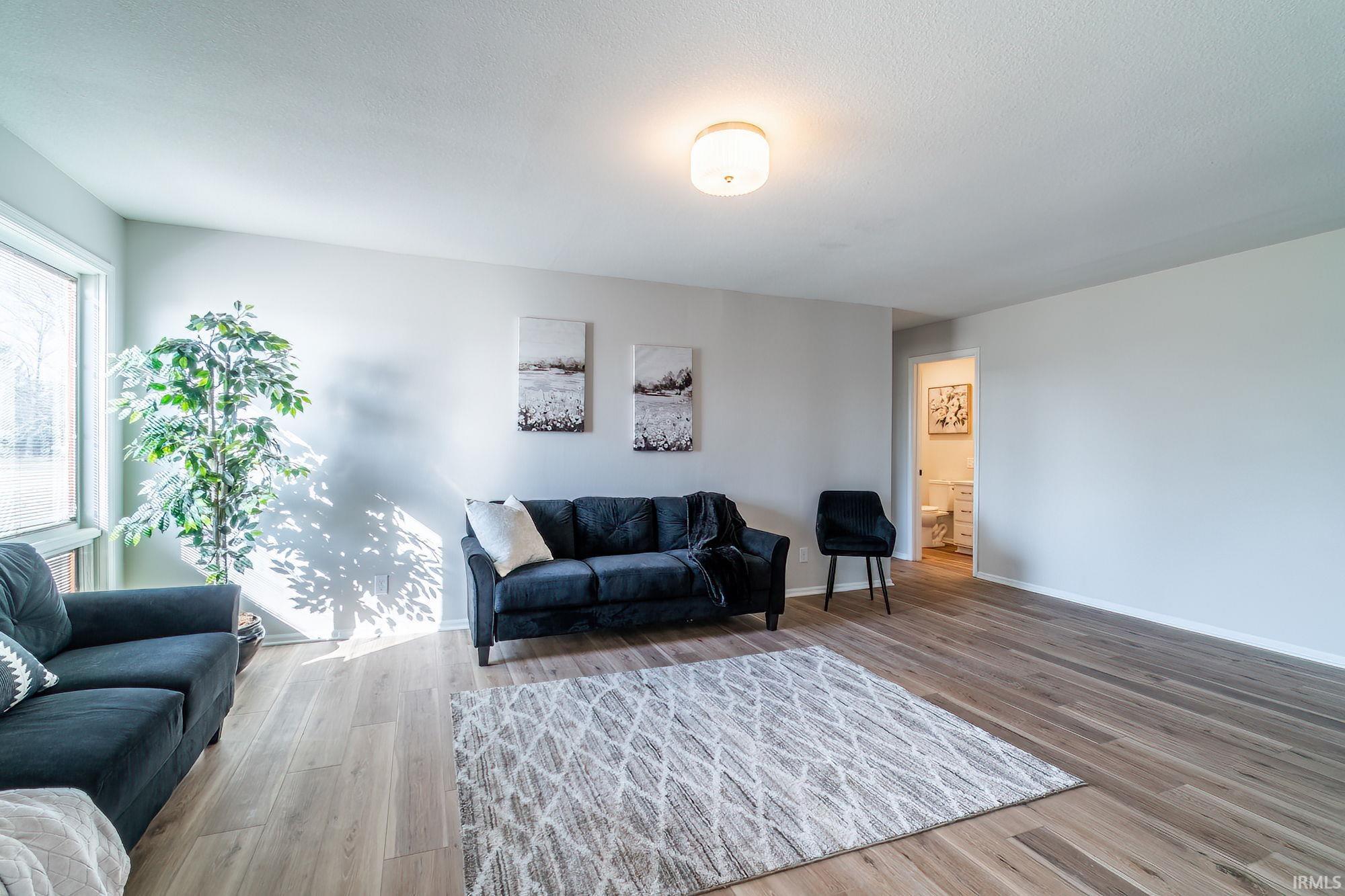 Living room featuring light wood-type flooring and baseboards
