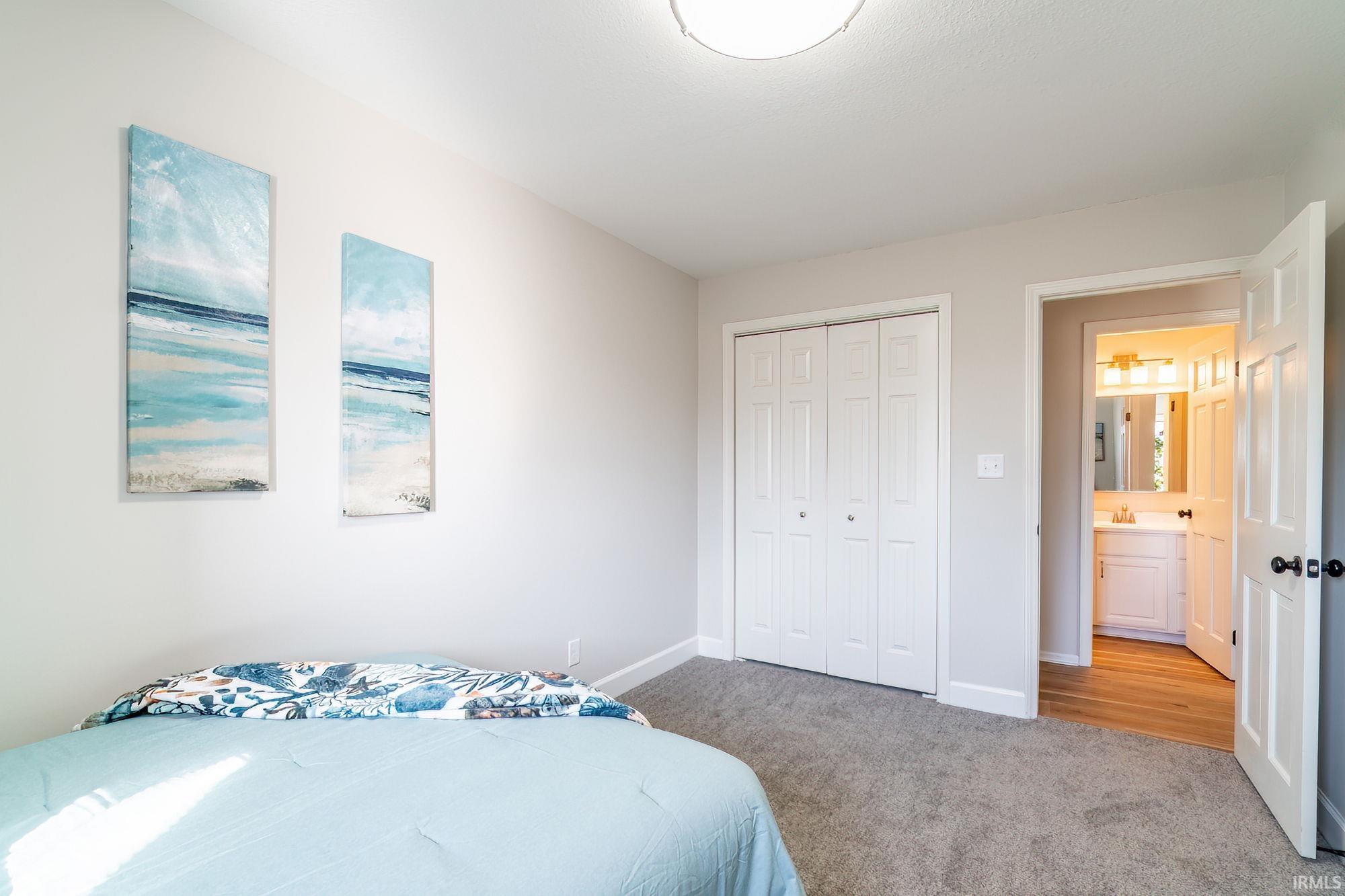 Bedroom featuring light carpet and a closet
