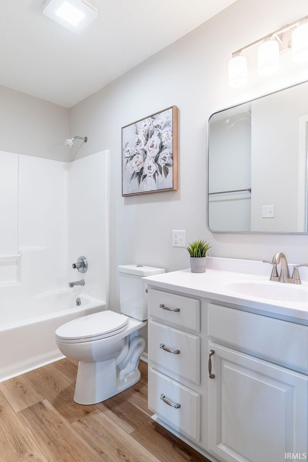 Bathroom featuring vanity, light wood-style flooring, and shower / tub combination
