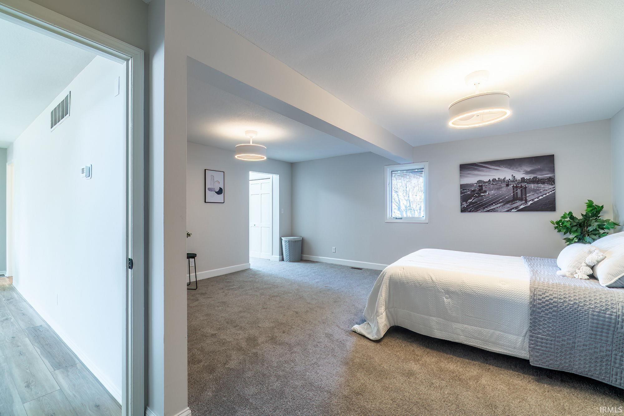 Bedroom with baseboards and light carpet