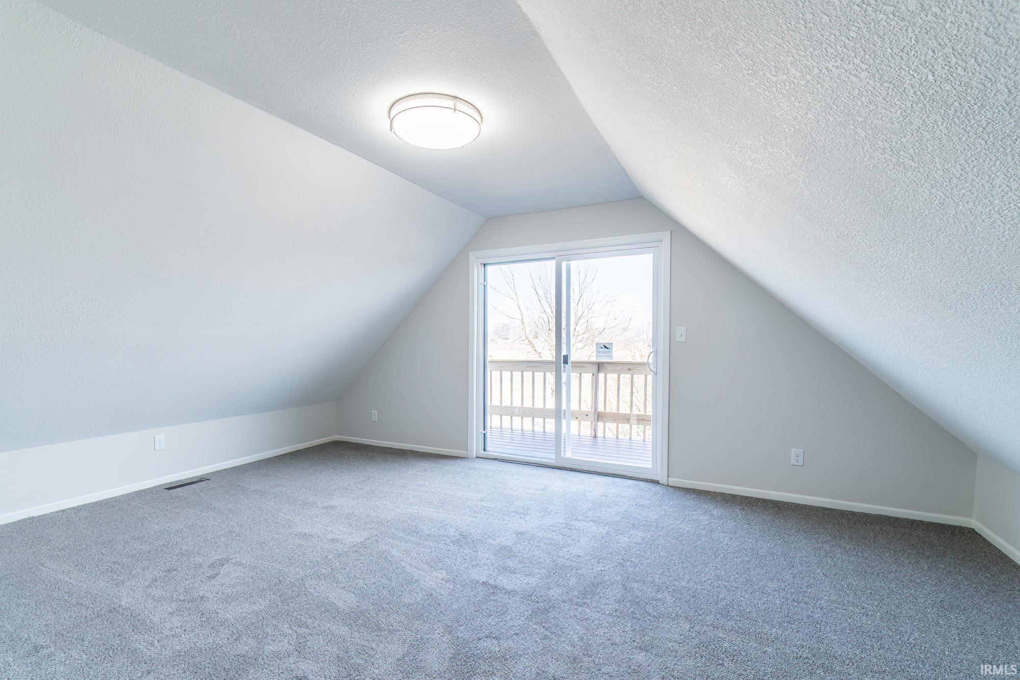 Bonus room with carpet floors and a textured ceiling