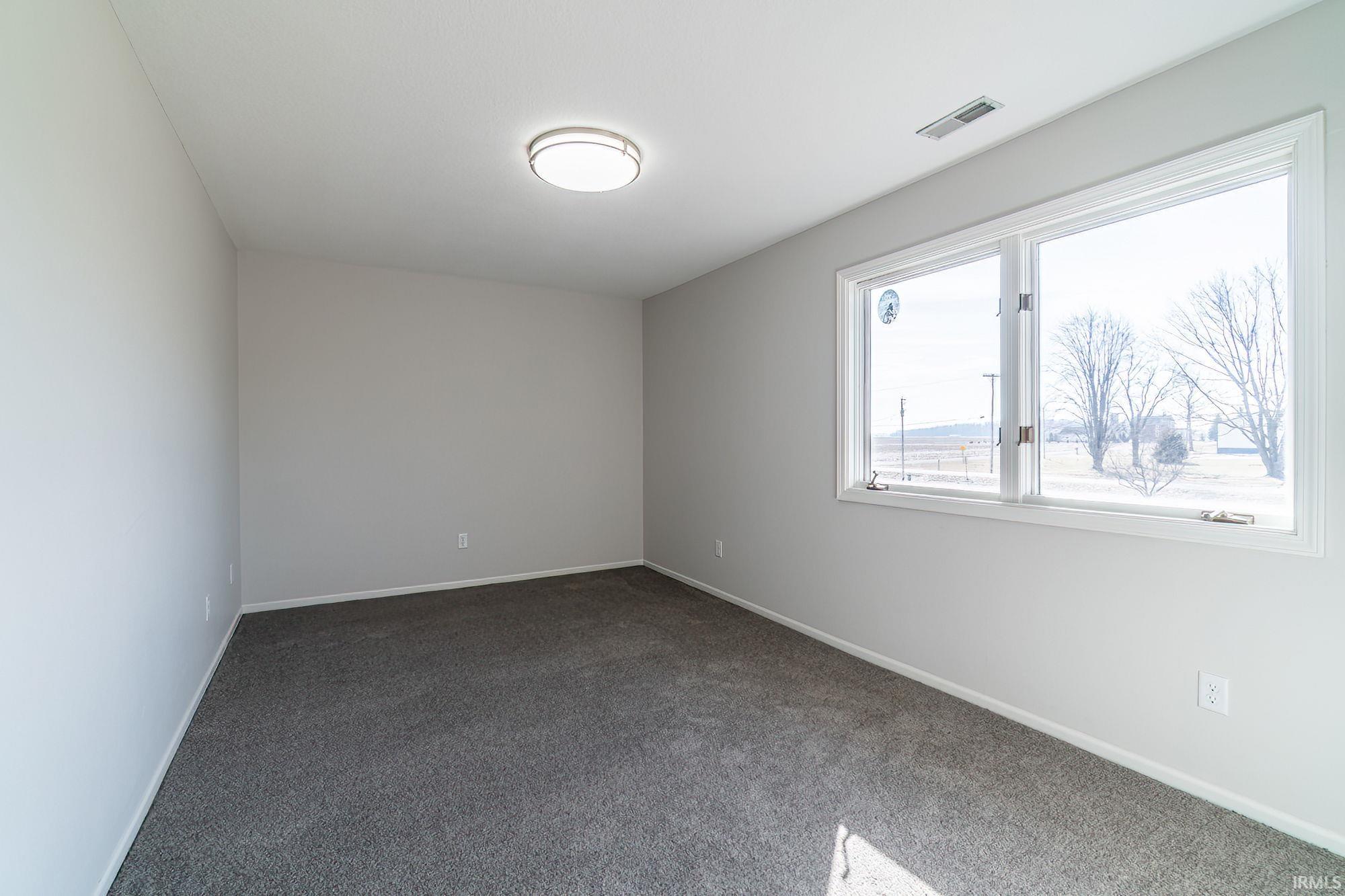 Spare room featuring carpet and baseboards