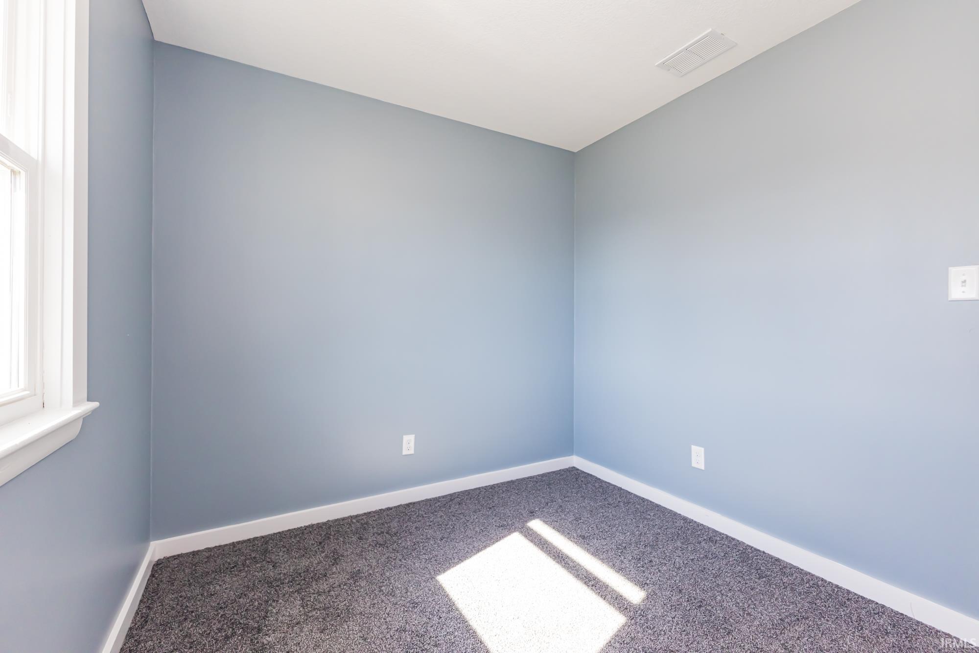 Carpeted empty room featuring baseboards