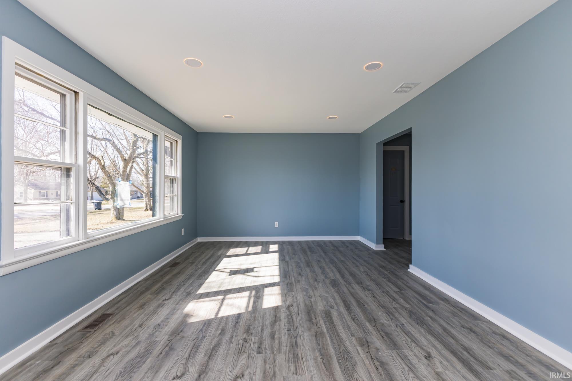 Unfurnished room with dark wood-style flooring and recessed lighting