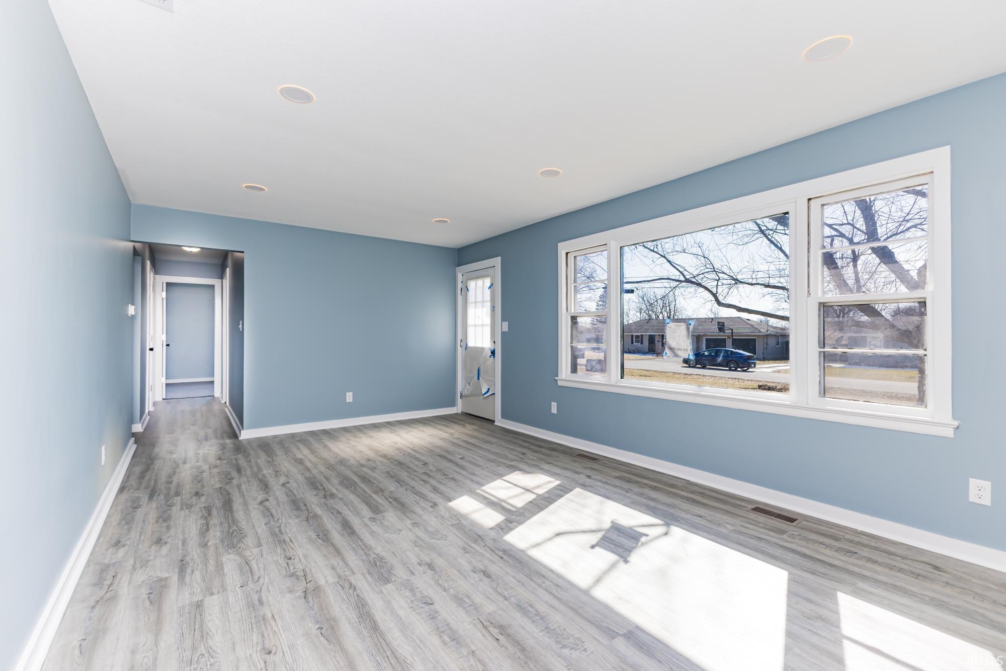 Unfurnished living room with baseboards and light wood-style floors