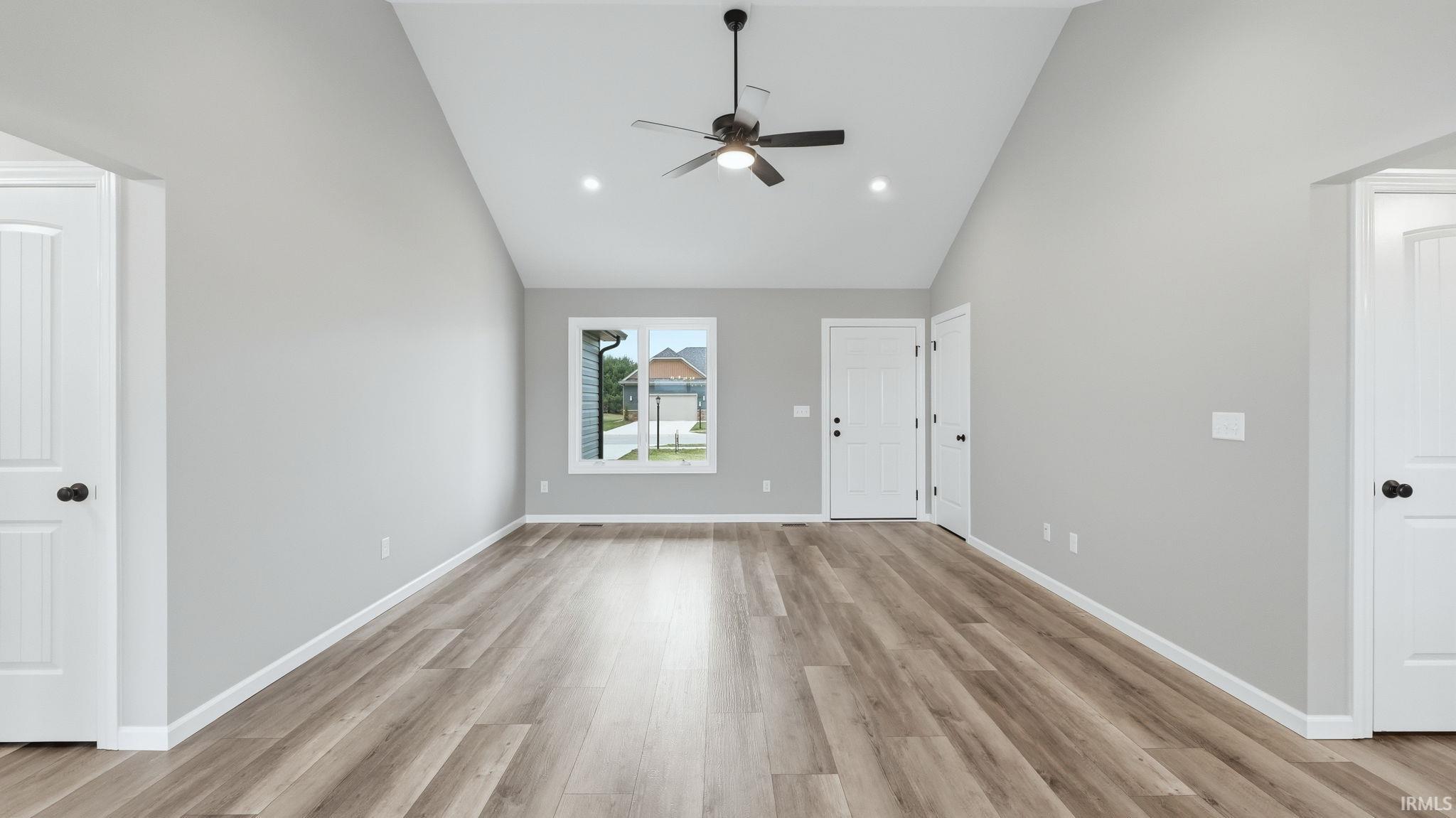 Unfurnished living room with a ceiling fan, light wood-style floors, lofted ceiling, and recessed lighting