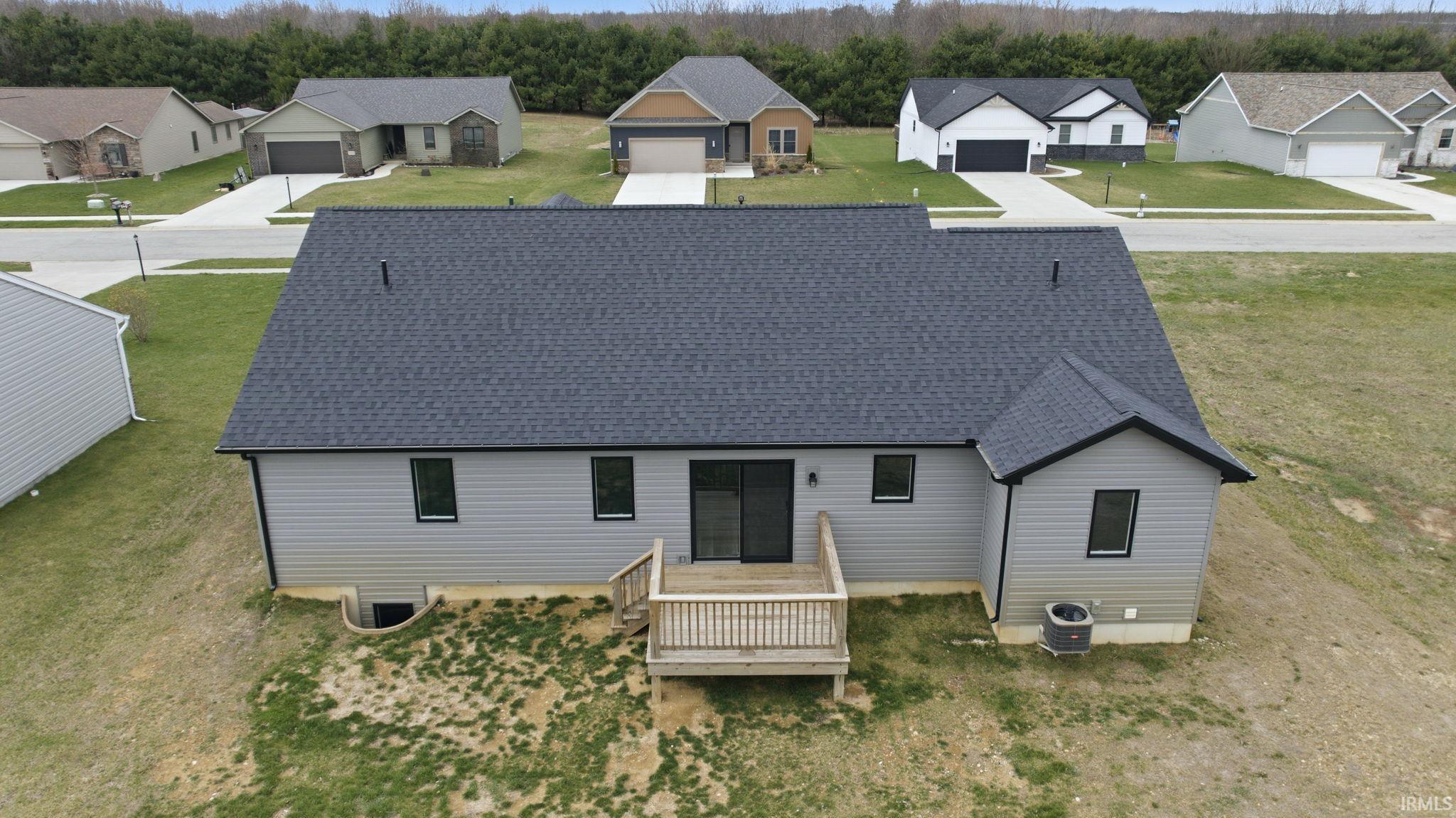 View of front of property featuring a shingled roof, view of scattered trees, a residential view, and a wooden deck