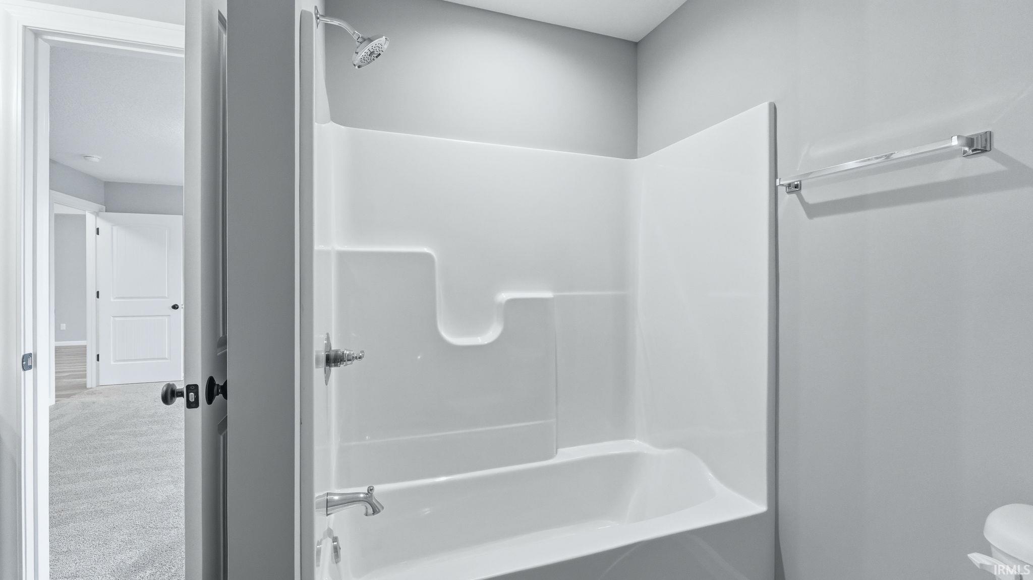 Bathroom with shower / bath combination and carpet floors