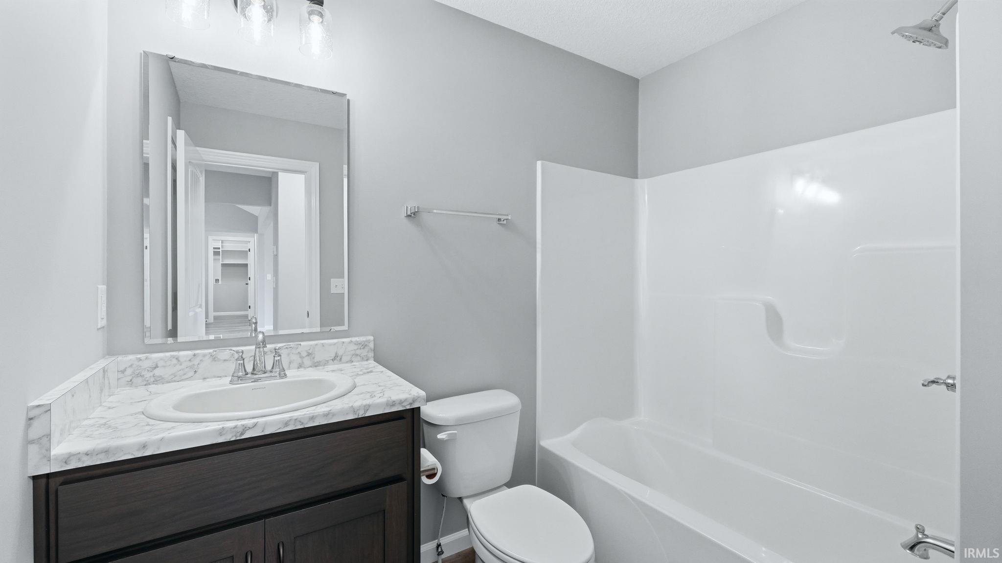 Full bath featuring vanity and washtub / shower combination