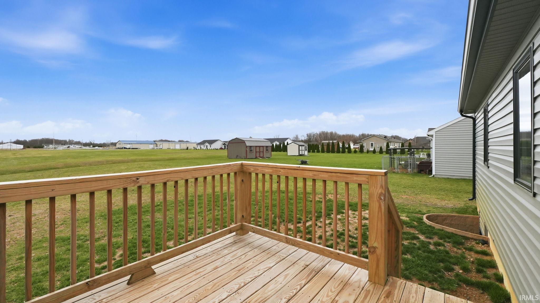 Deck with a storage shed, a residential view, and a yard