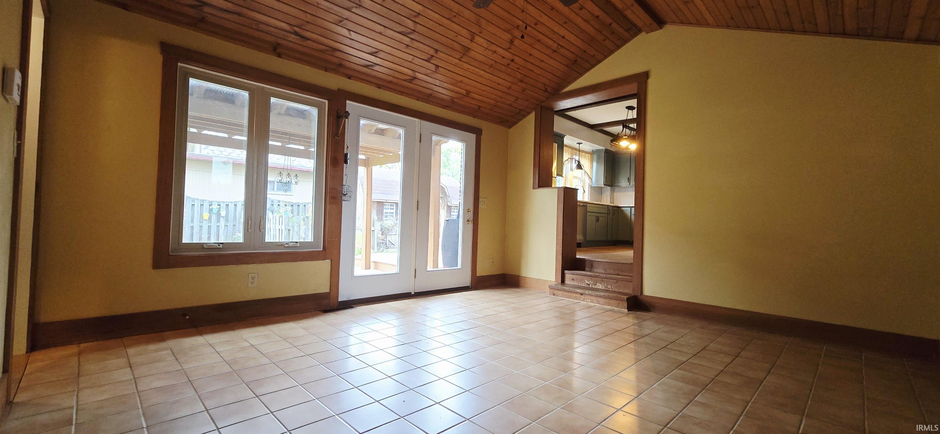 Unfurnished living room with wood ceiling and light tile patterned floors