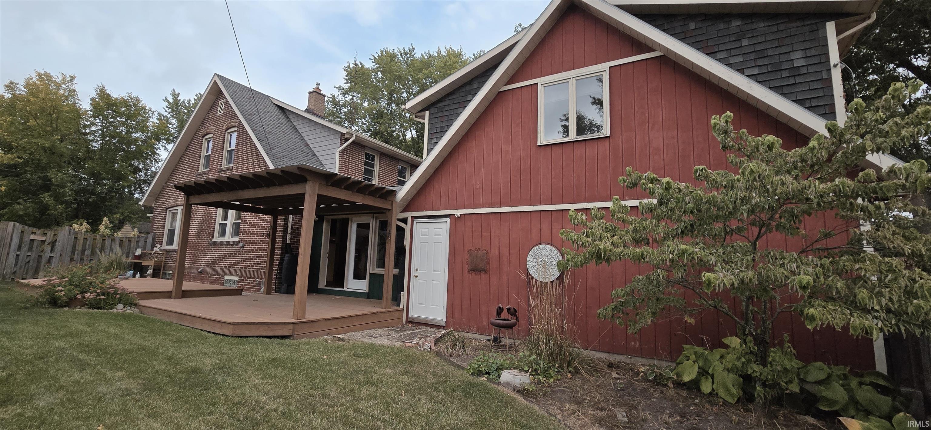 Back of property featuring a wooden deck and a shingled roof