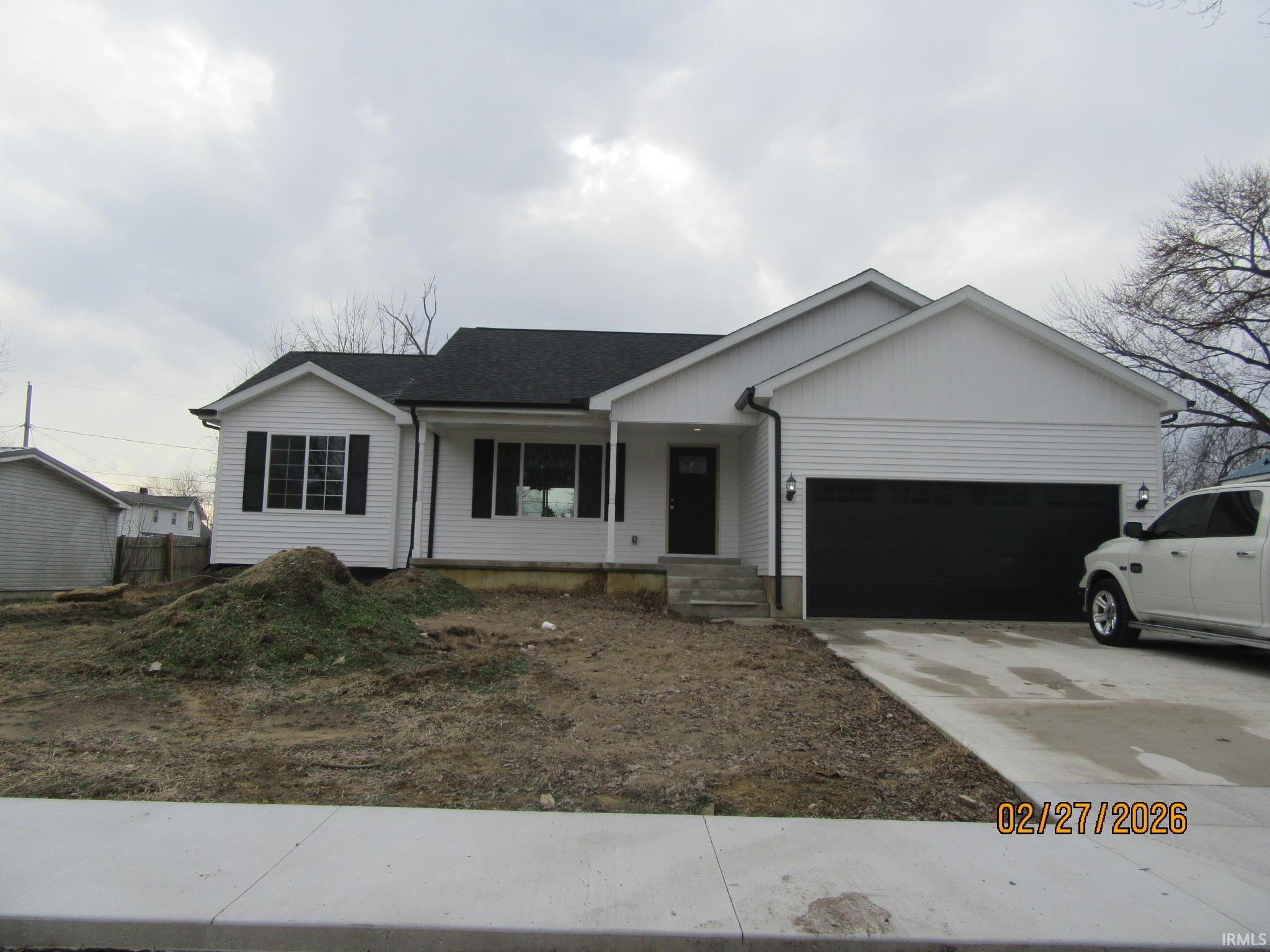Single story home featuring a porch, a garage, concrete driveway, board and batten siding, and a shingled roof