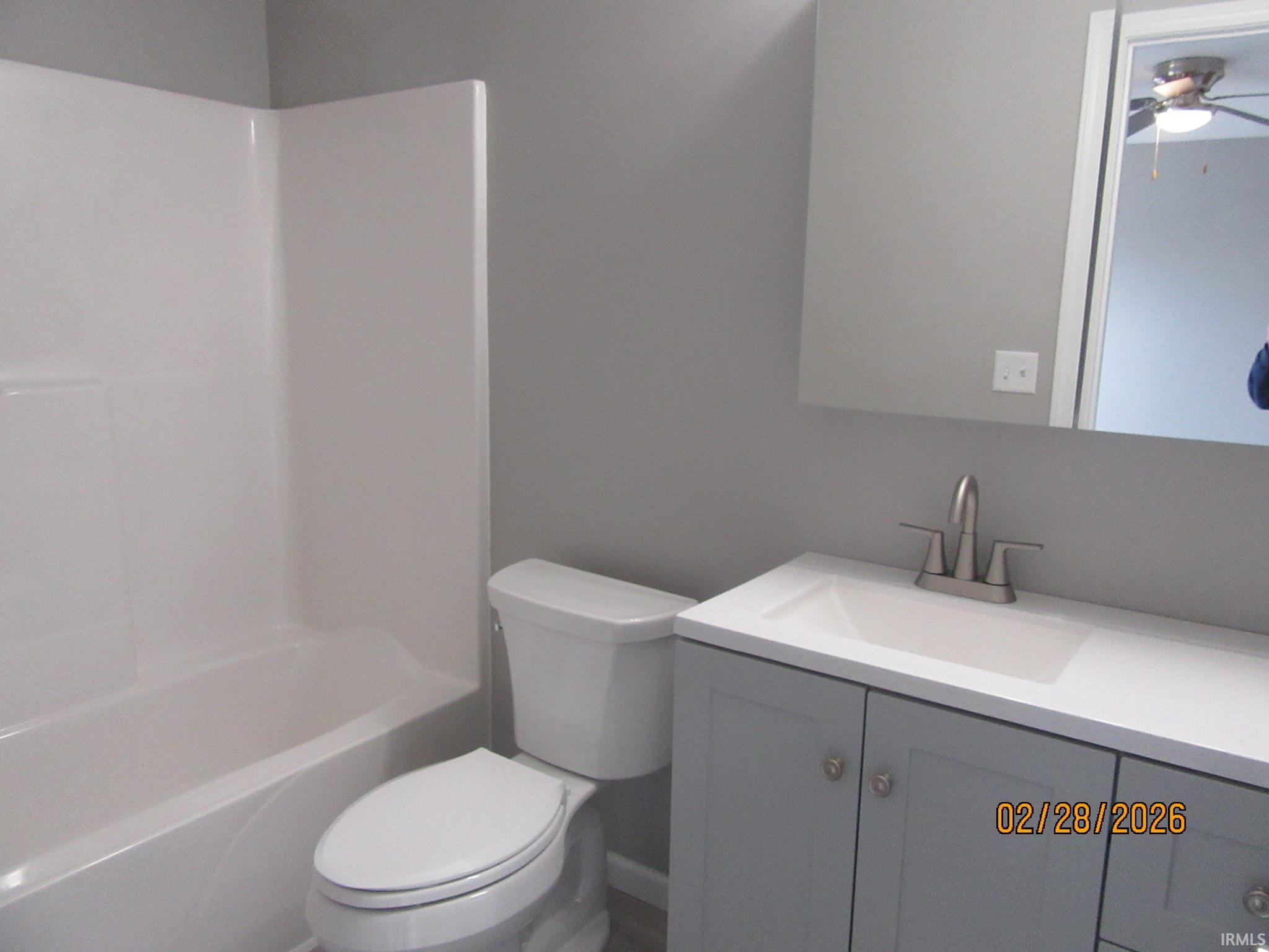 Full bathroom with vanity, ceiling fan, and tub / shower combination
