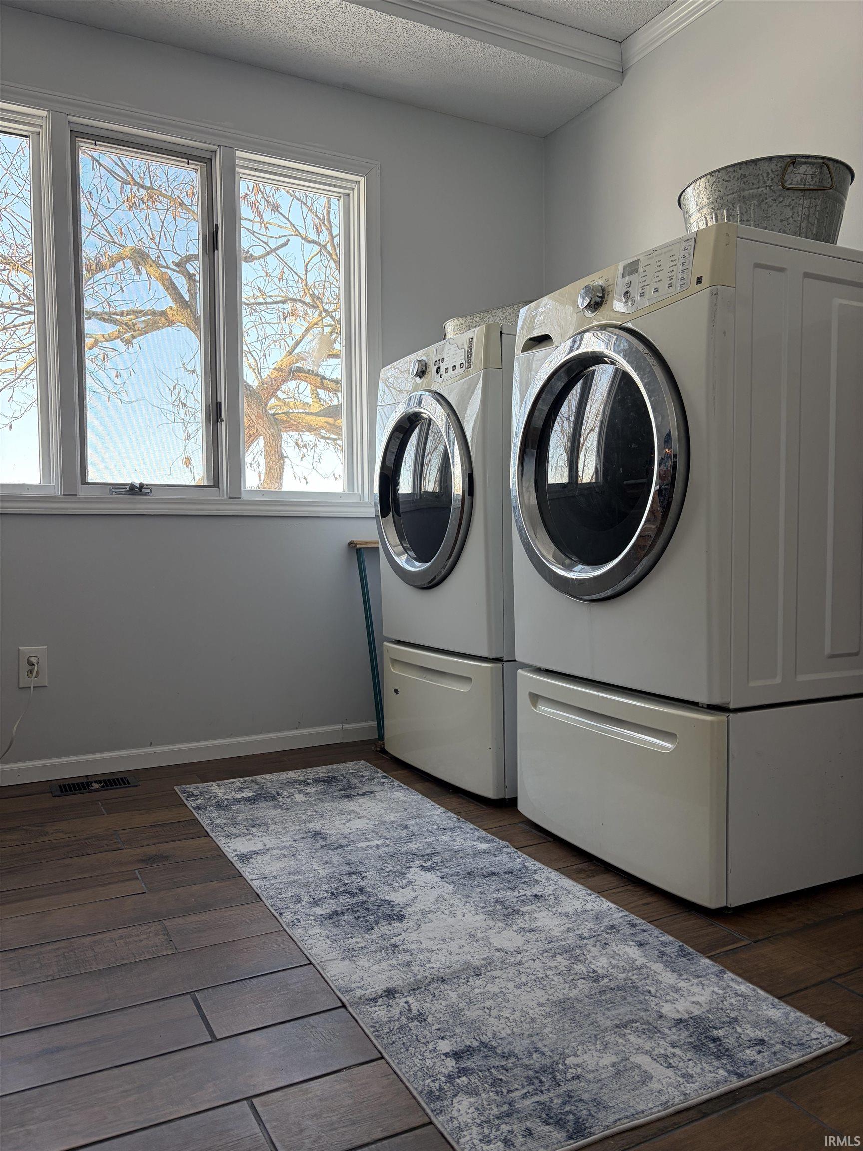 Washroom featuring dark wood-style floors, a textured ceiling, and separate washer and dryer