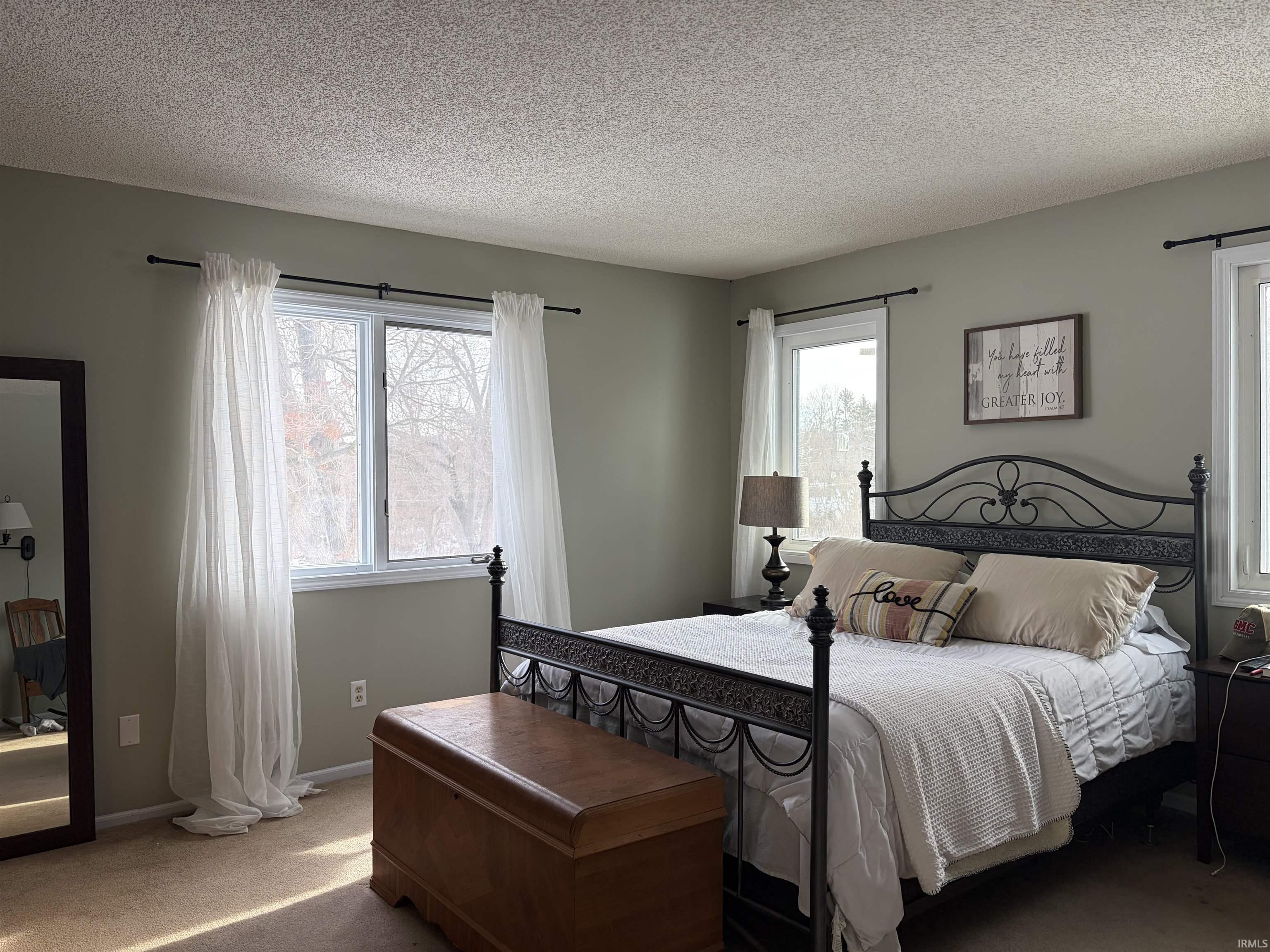 Bedroom with carpet floors and a textured ceiling