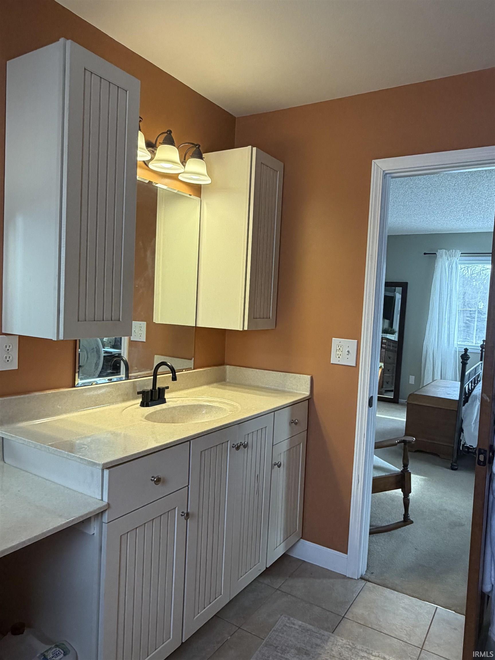 Bathroom featuring vanity, ensuite bathroom, light tile patterned floors, and light carpet