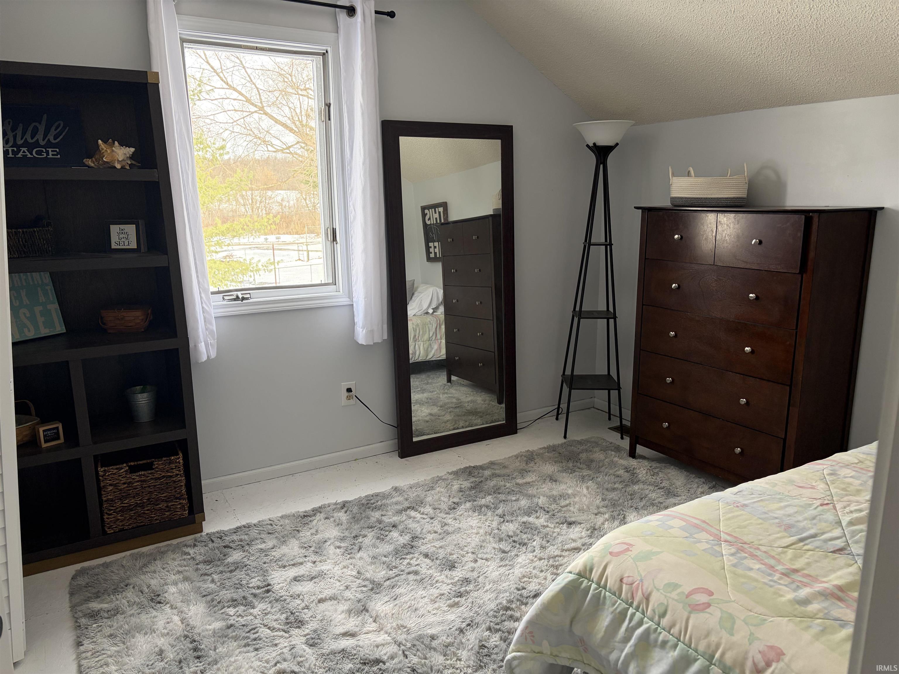 Bedroom with a textured ceiling and lofted ceiling
