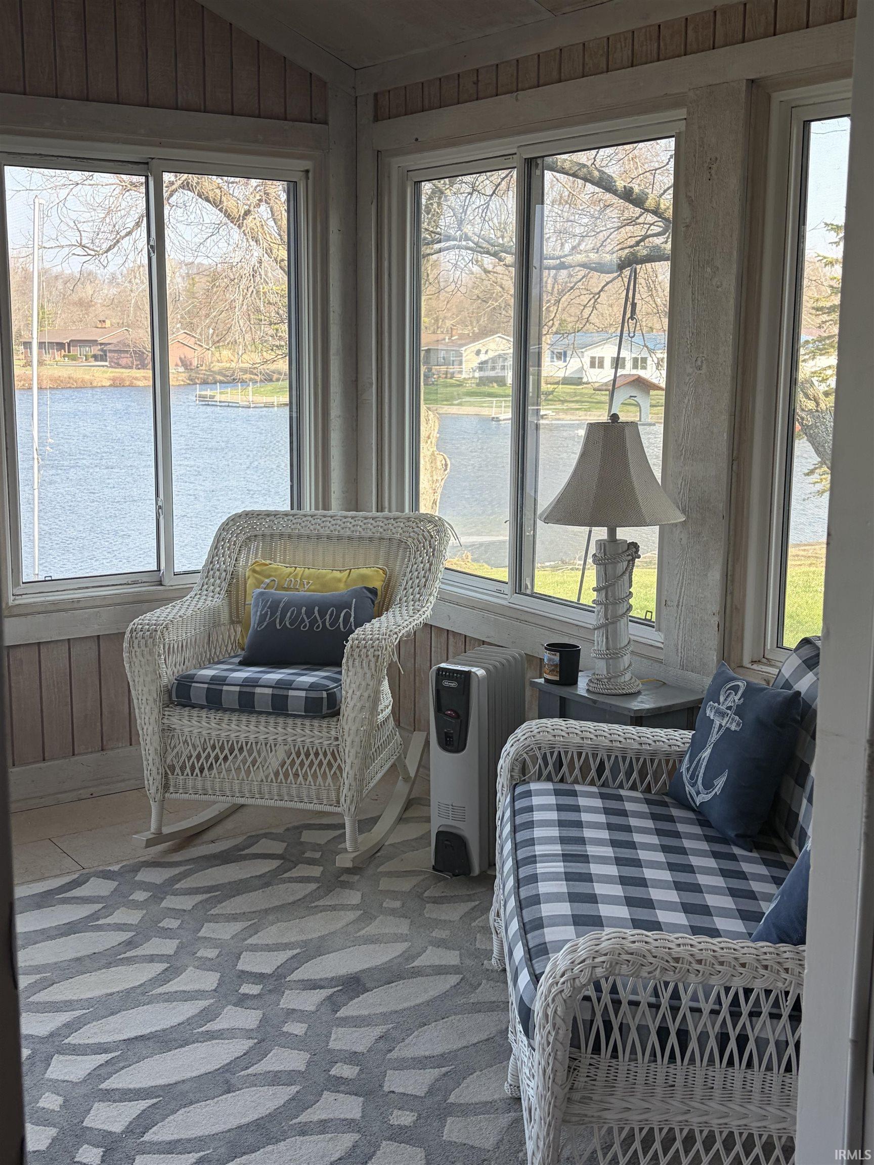 Sunroom / solarium featuring a water view, healthy amount of natural light, and lofted ceiling