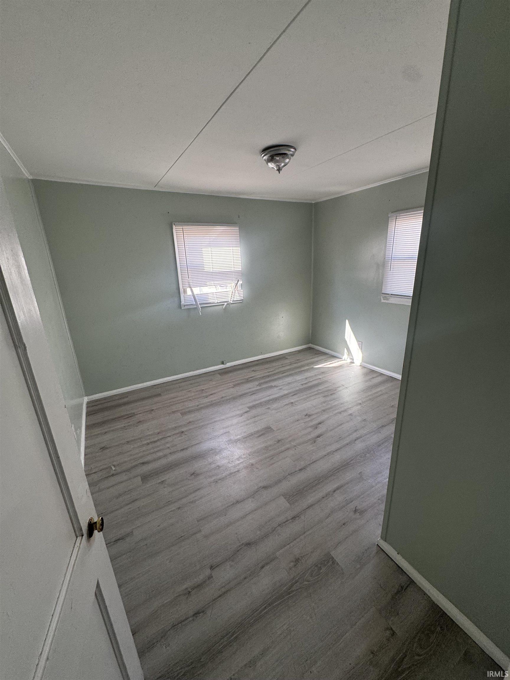Unfurnished room featuring wood finished floors and baseboards