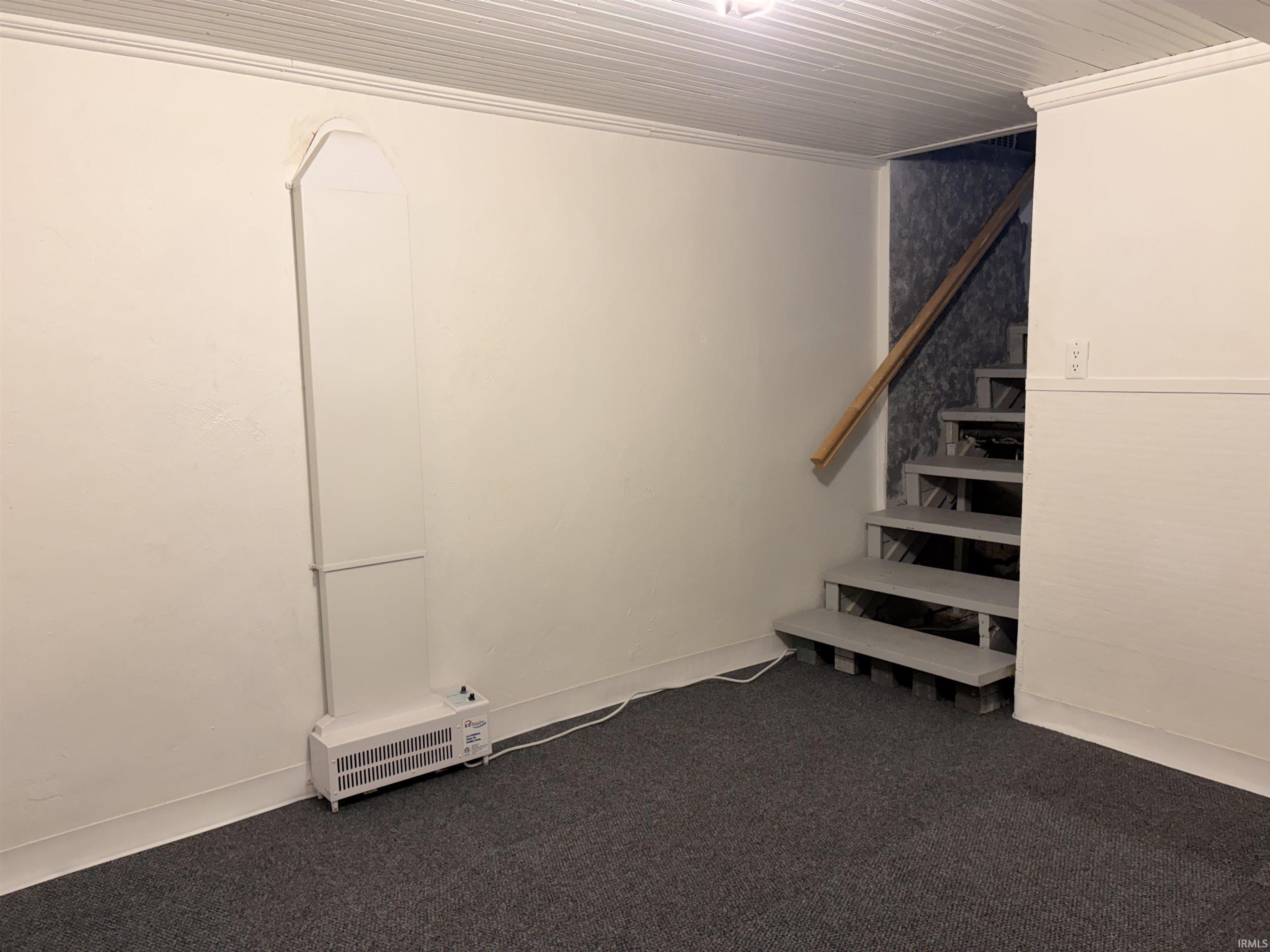 Below grade area with dark carpet and stairway