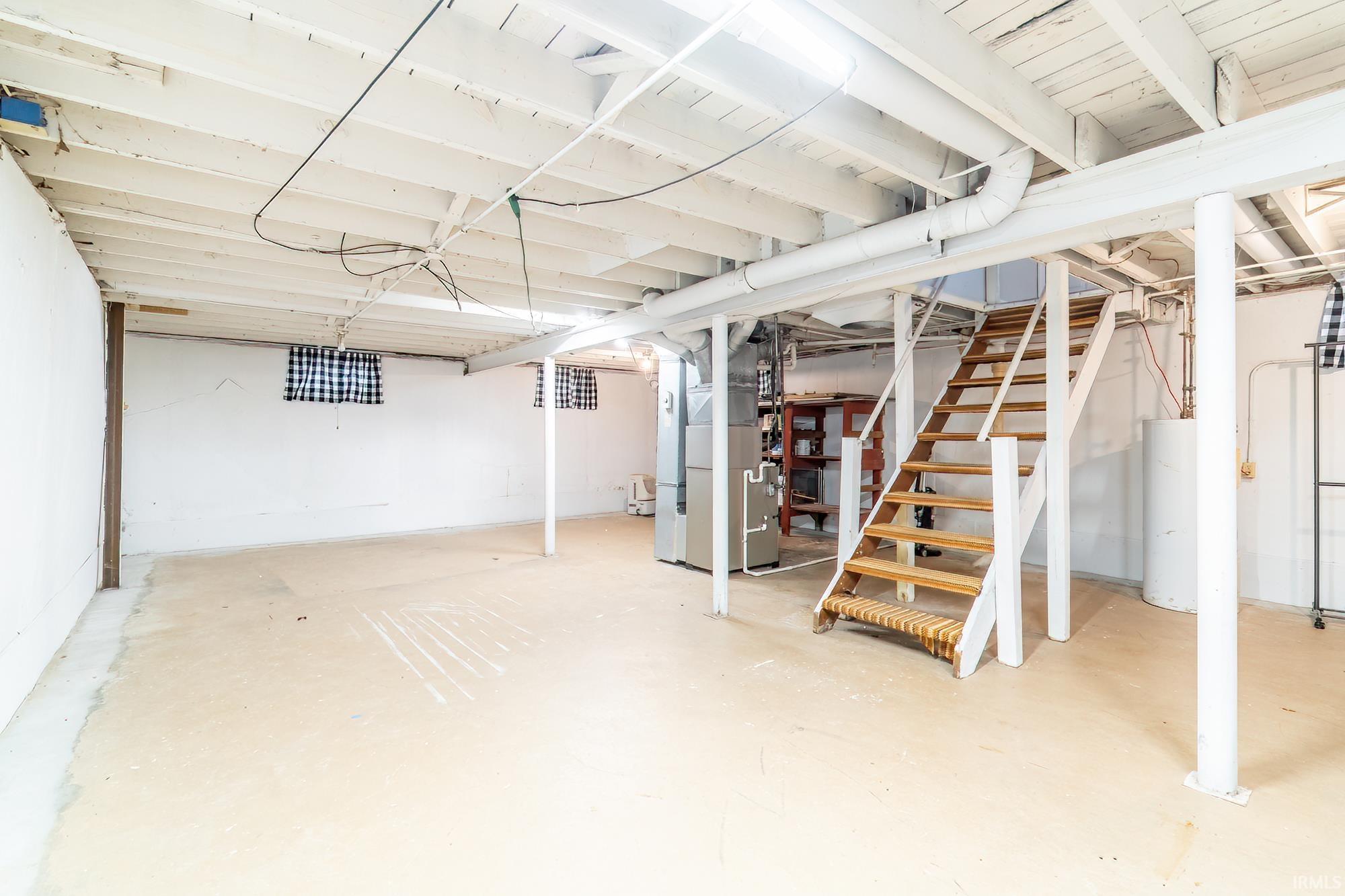 Unfinished below grade area with heating unit and water heater