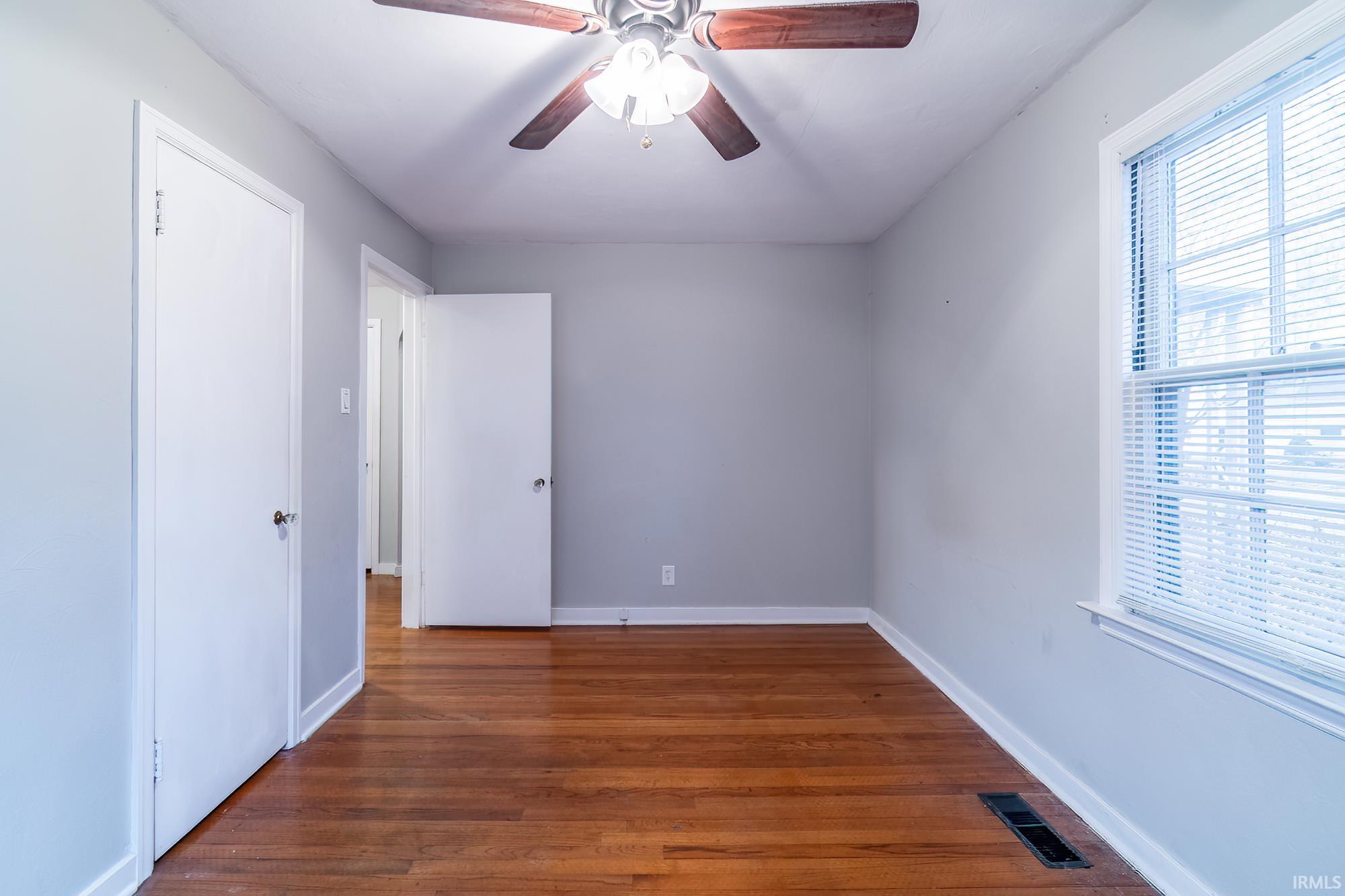Spare room featuring dark wood finished floors and a ceiling fan