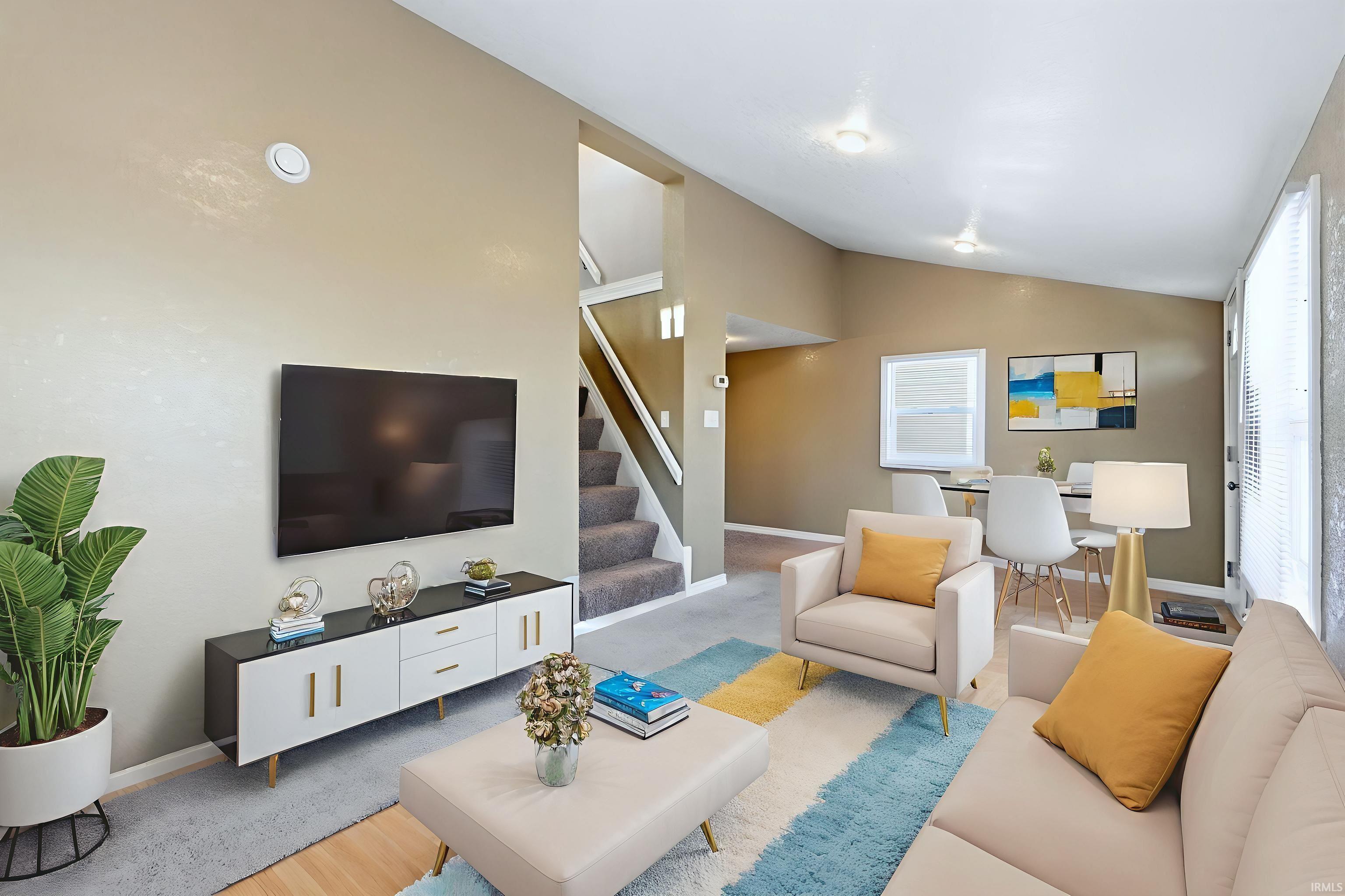 Living room with light colored carpet and vaulted ceiling