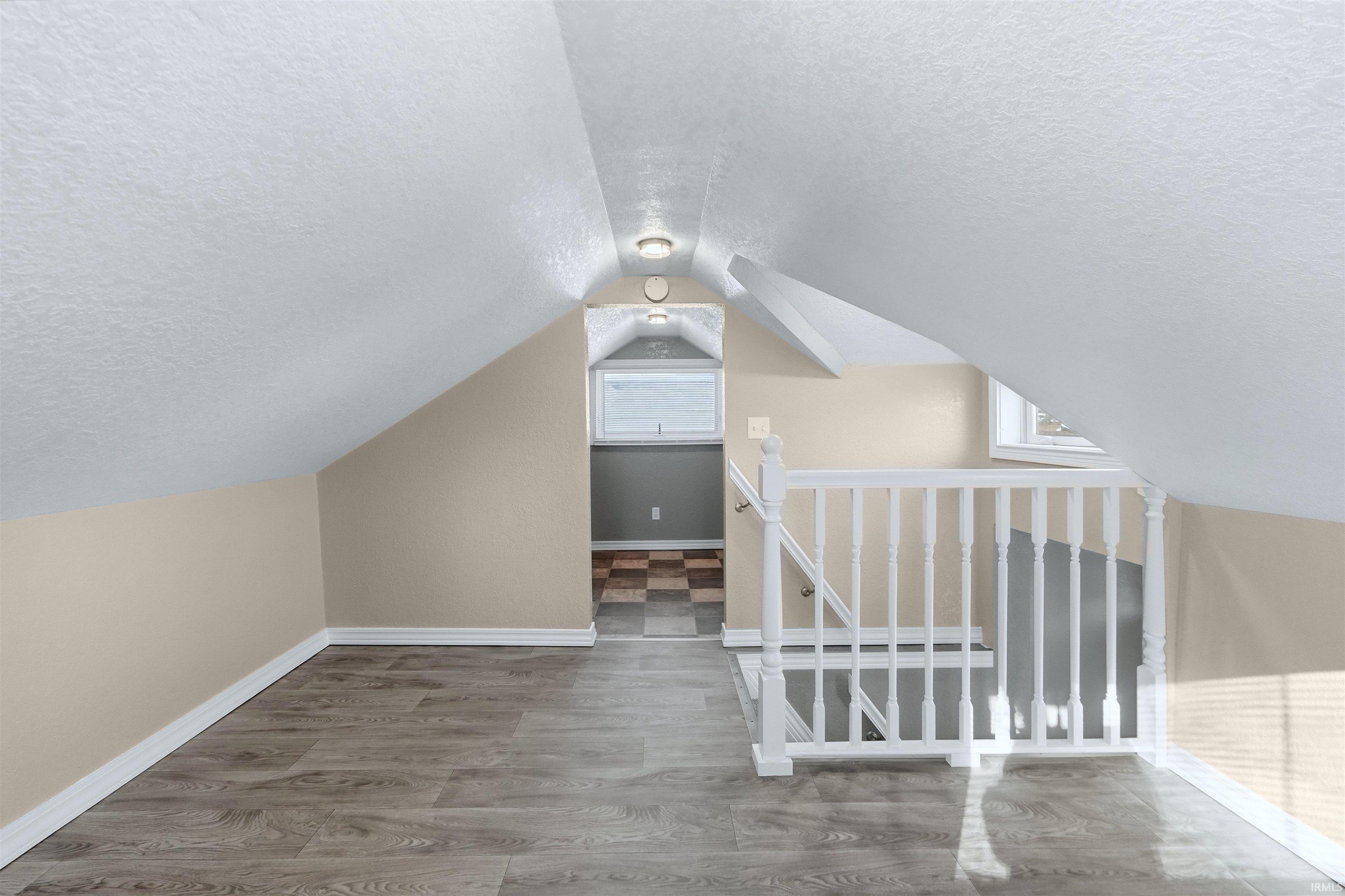 Bonus room with a textured ceiling and wood finished floors