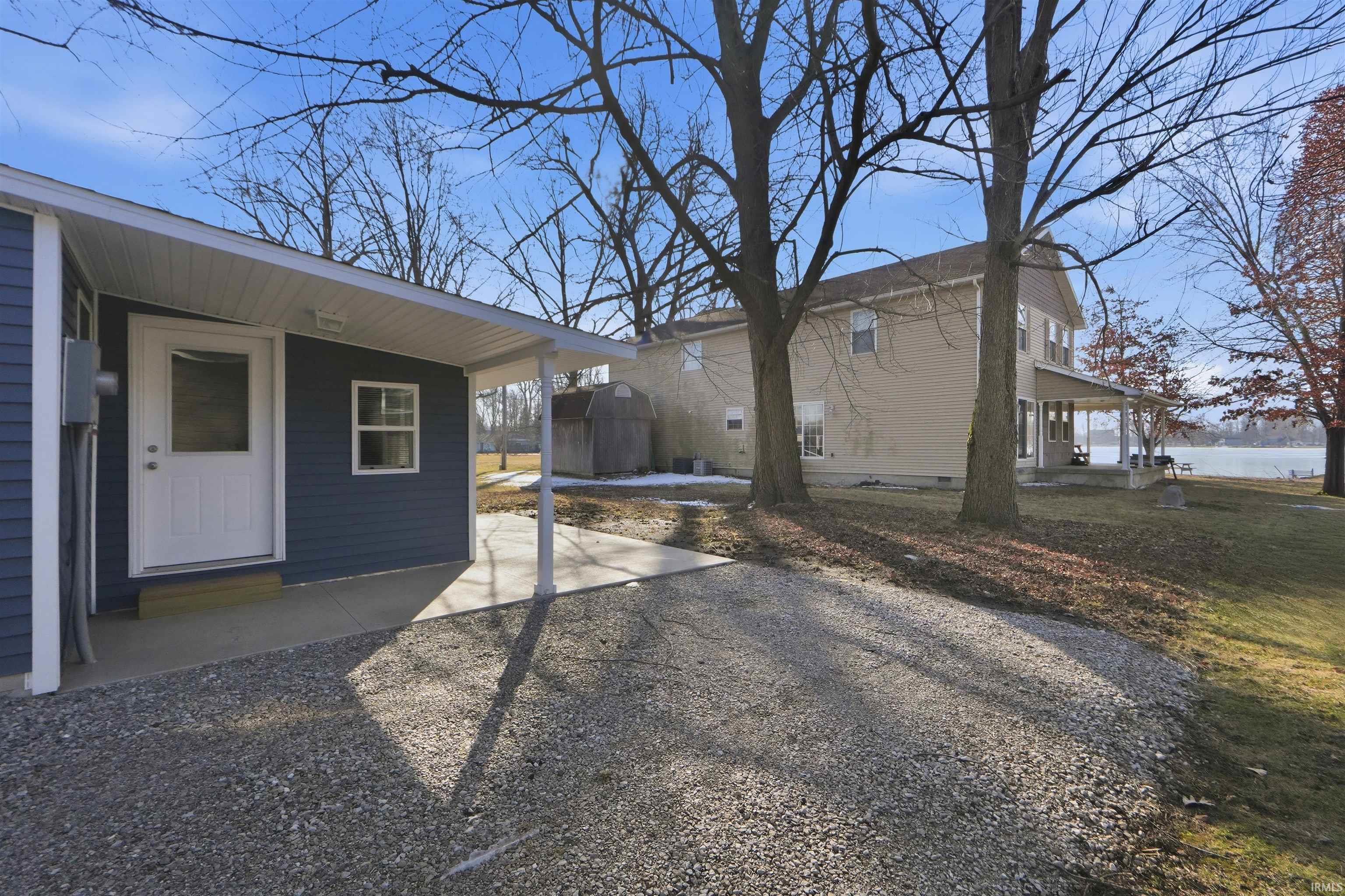 Back of house with a patio area and a storage shed