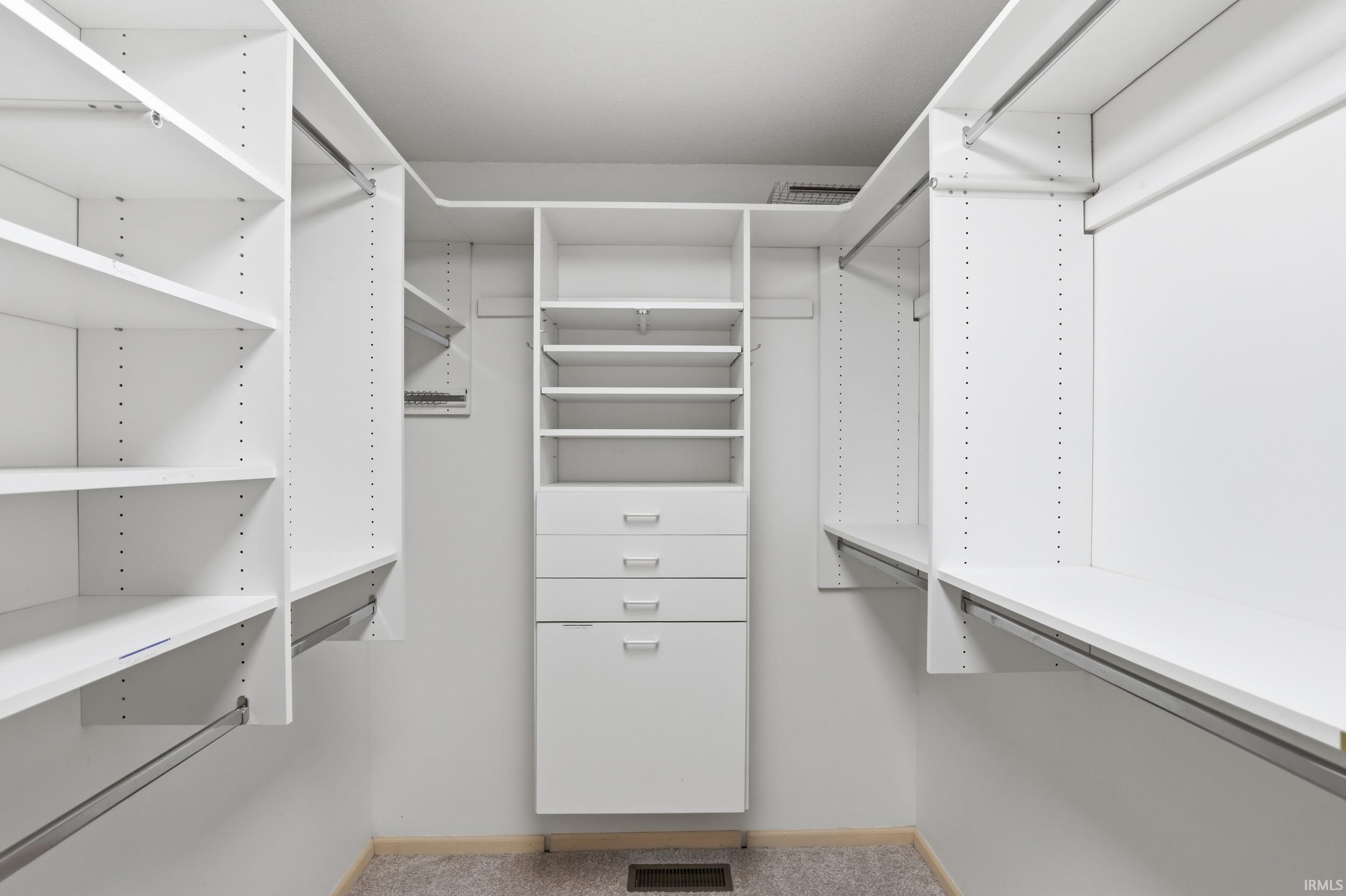 Walk in closet with light carpet
