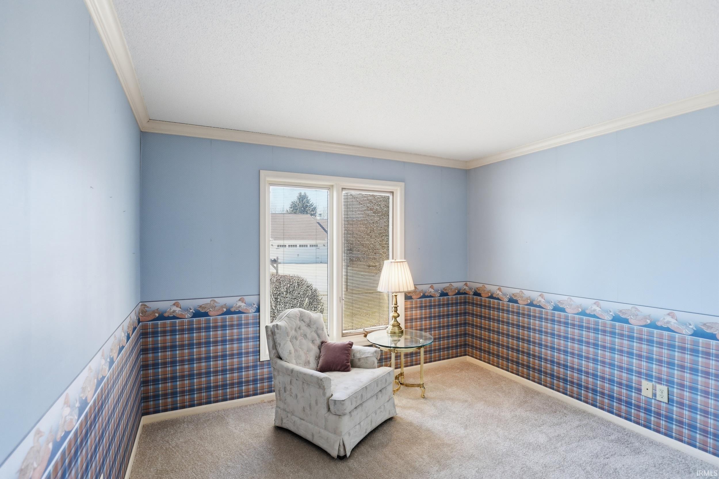Sitting room featuring wallpapered walls, ornamental molding, wainscoting, and carpet floors